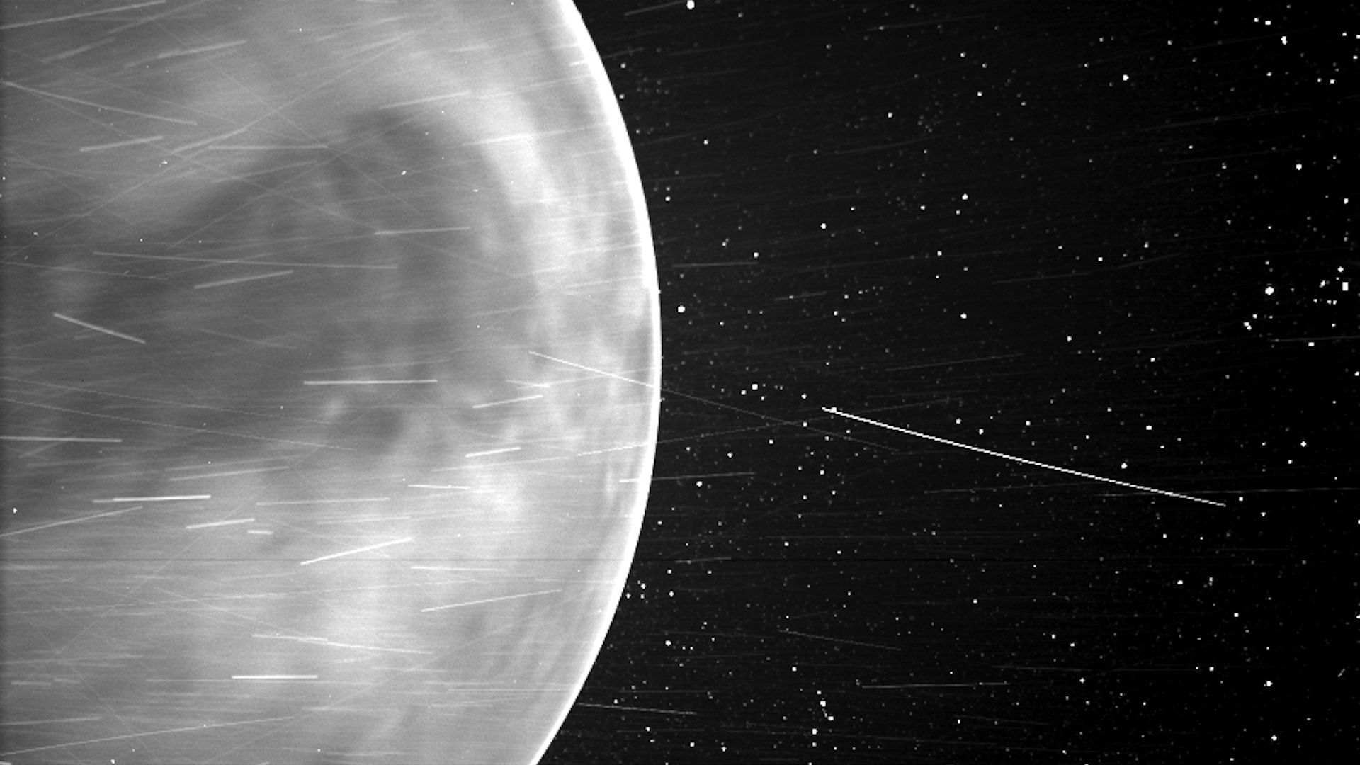 A black and white image of Venus with streaks of artifacts in the photo