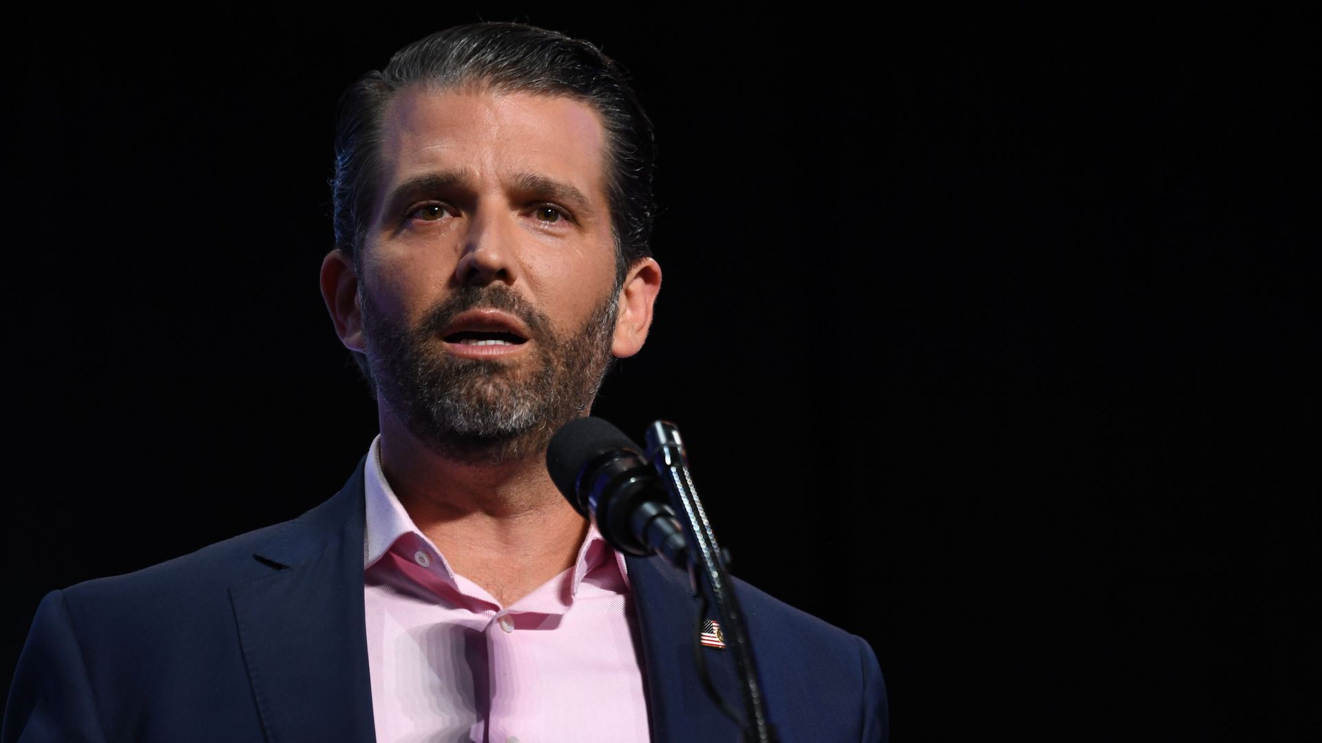 Donald Trump Jr. in front of a microphone