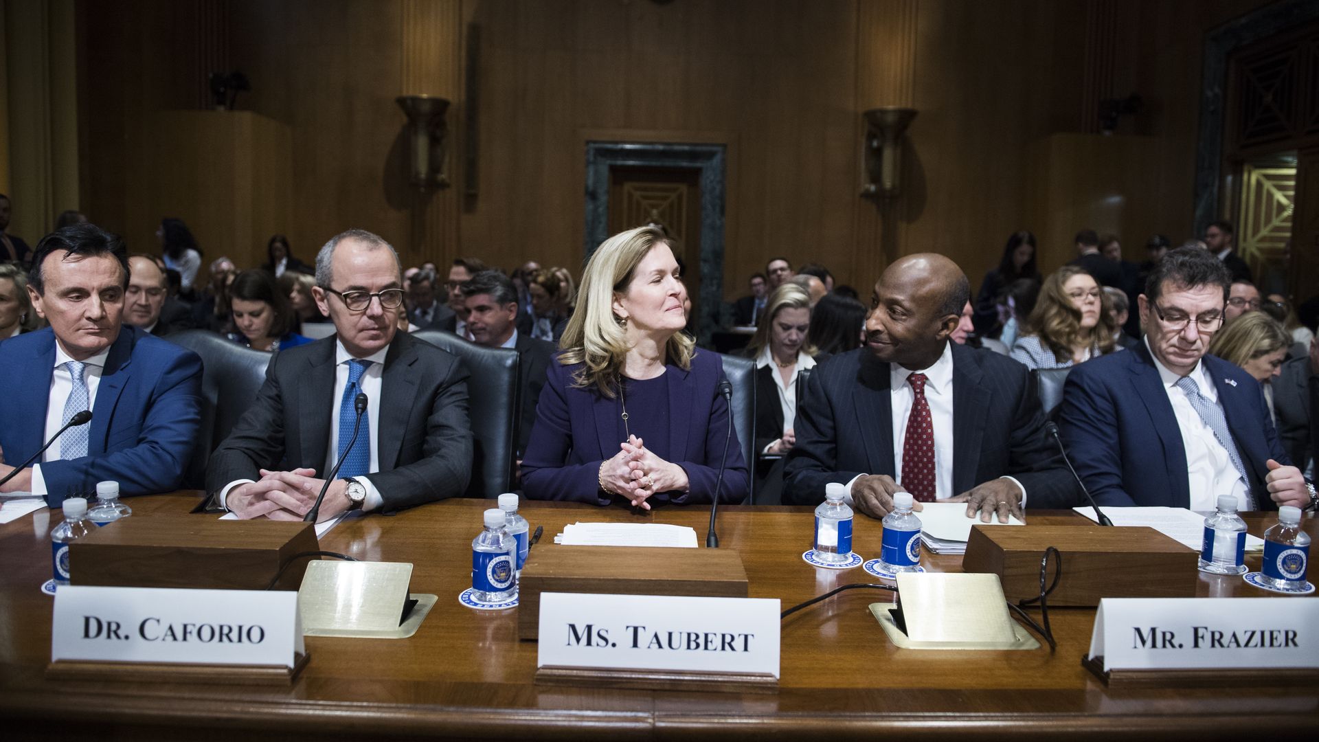 Pharmaceutical executives sit behind a table during U.S. Senate testimony.