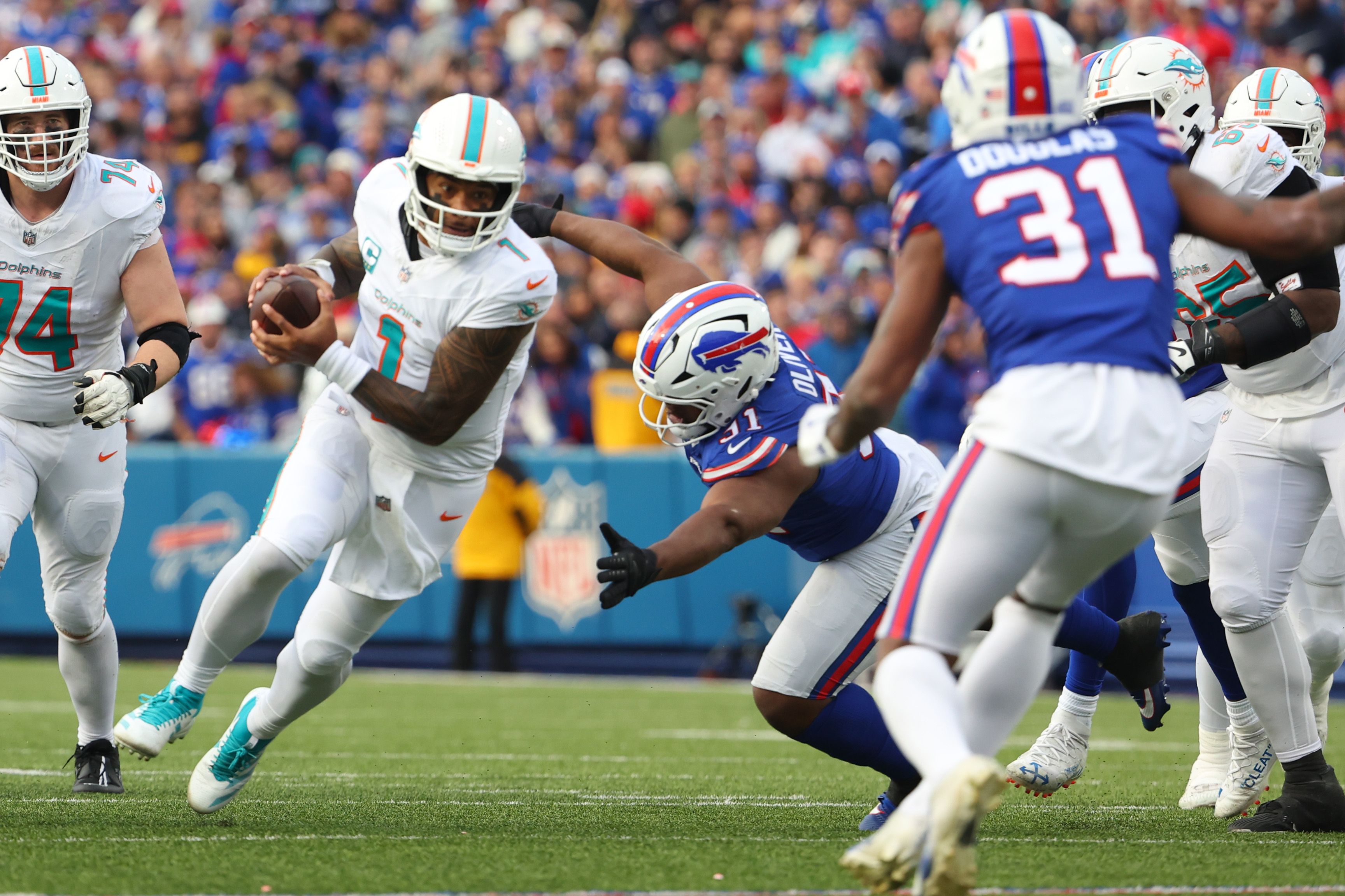 Tua Tagovailoa #1 of the Miami Dolphins carries the ball against Ed Oliver #91 of the Buffalo Bills during the fourth quarter at Highmark Stadium on November 03, 2024 in Orchard Park, New York. (Photo by Timothy T Ludwig/Getty Images)
