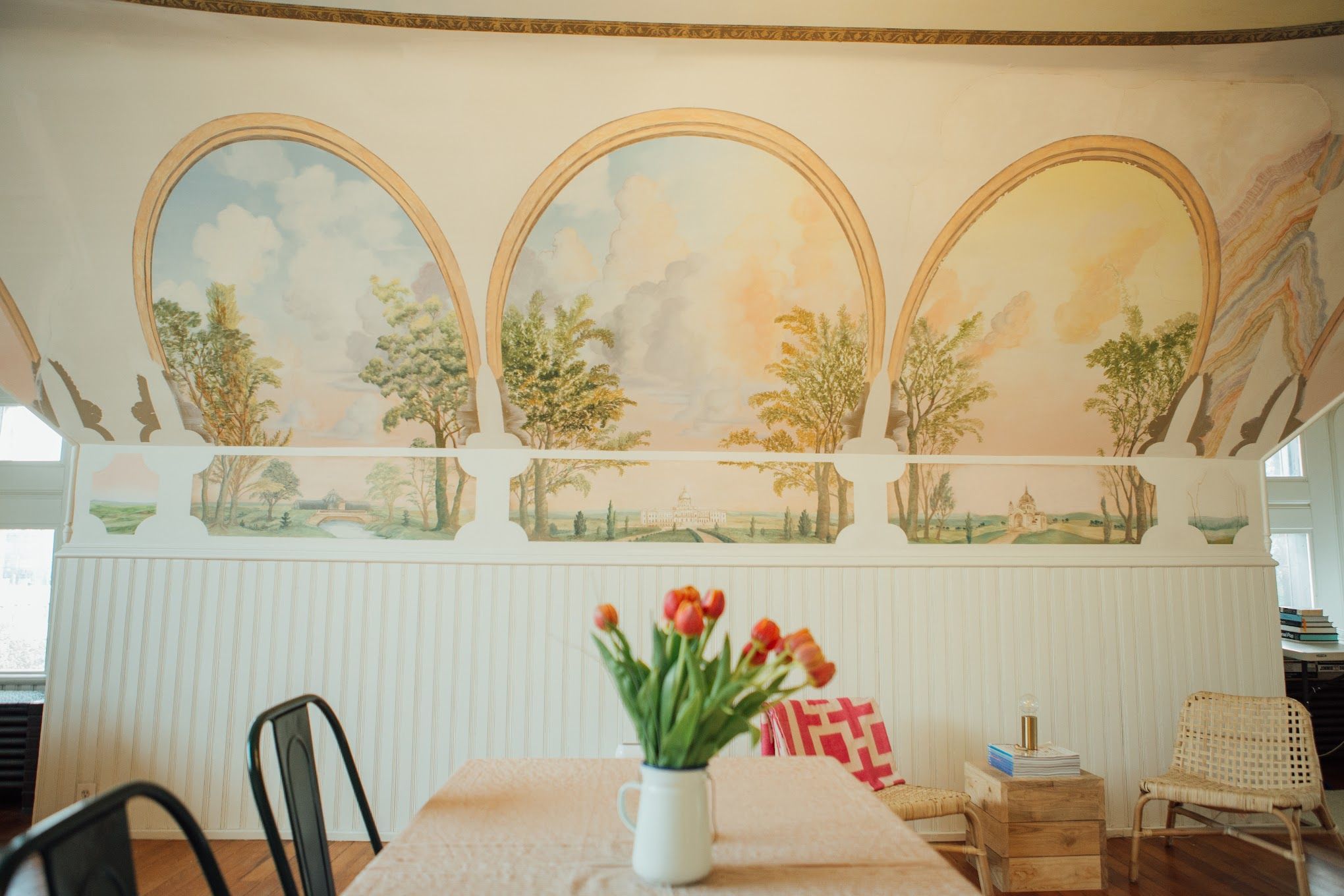 A photo of a wall with murals of the outdoors.