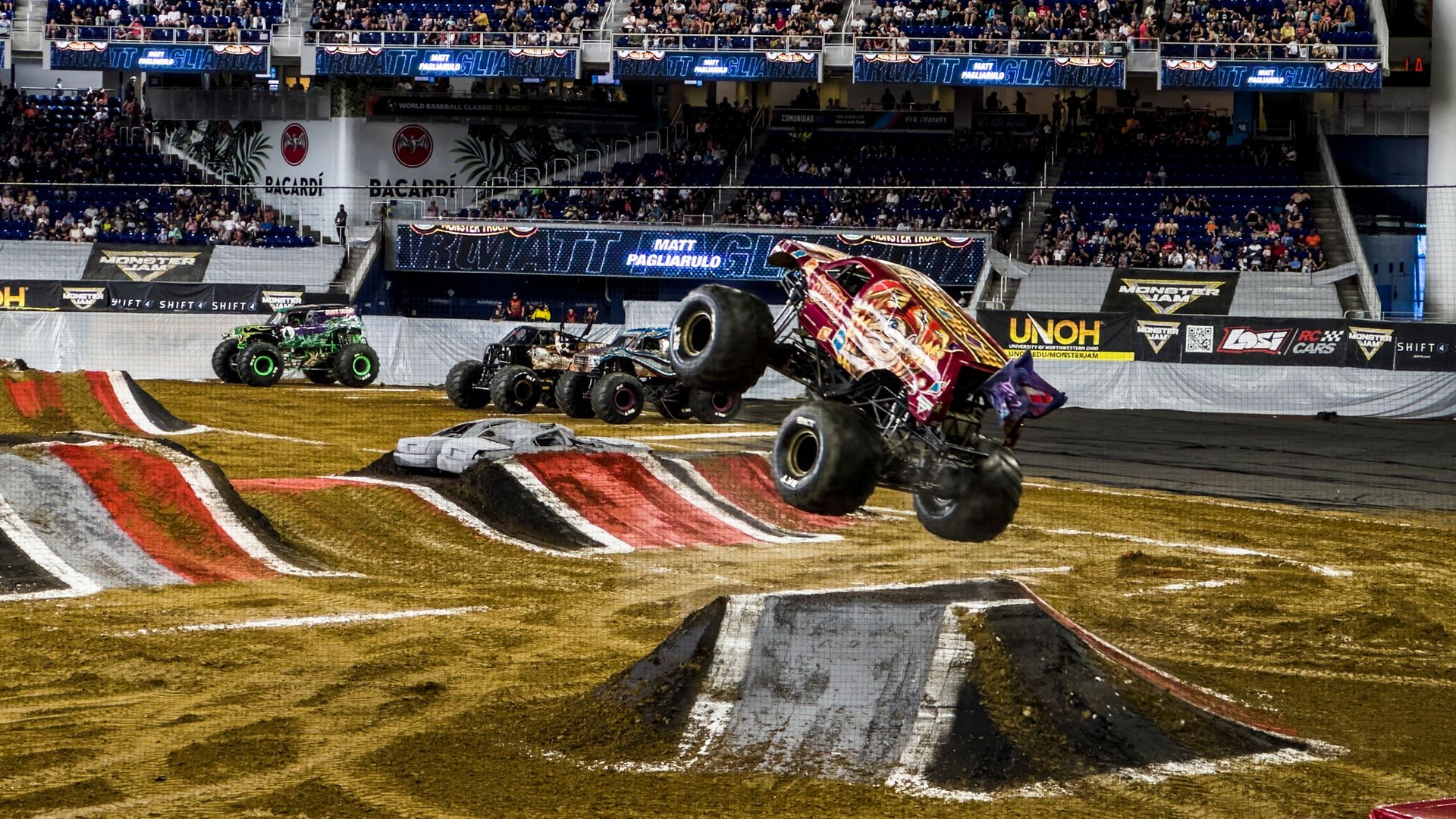 Monster Trucks in an arena dirt course.