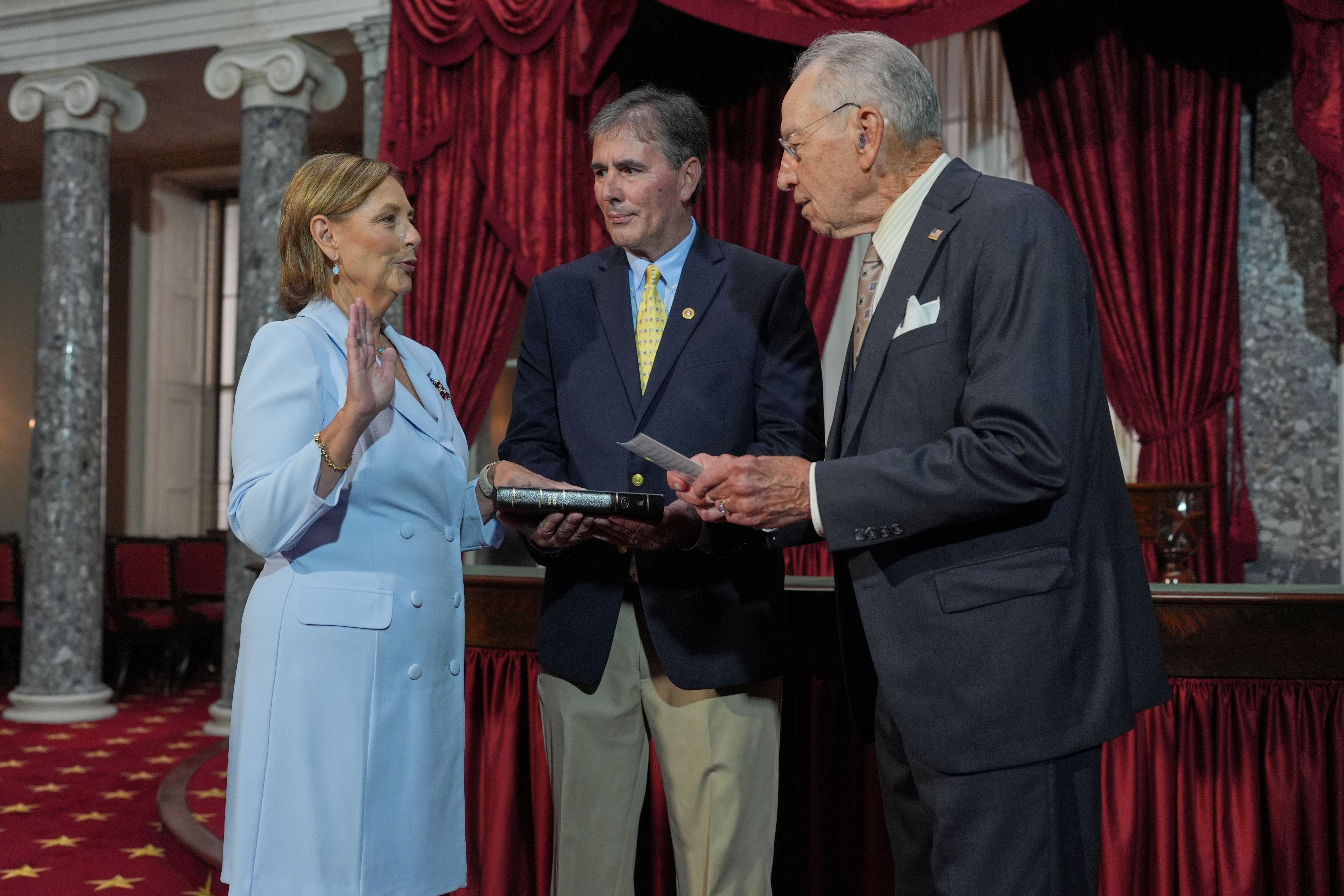 Darline Graham, sister of Sen. Lindsey Graham, R-S.C., is ceremonially sworn-in by President Pro Tempore of the Senate, Chuck Grassley, R-Iowa, in the Old Senate Chamber at the Capitol in Washington, Tuesday, July 14, 2026, as her husband Larry Nordone holds the Bible.