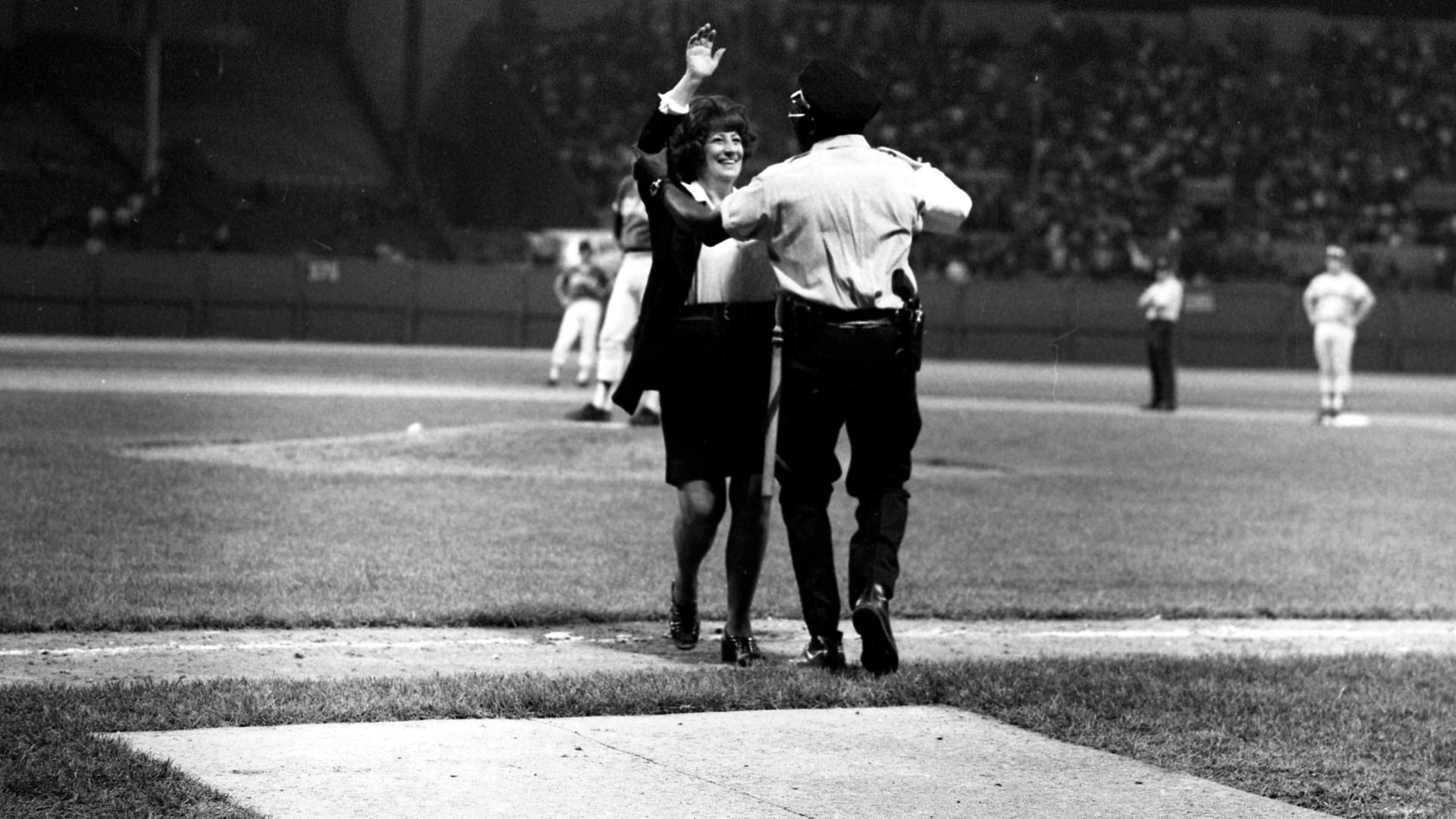A photo of a woman being escorted off the baseball field on June 4, 1974, by a police officer in Cleveland