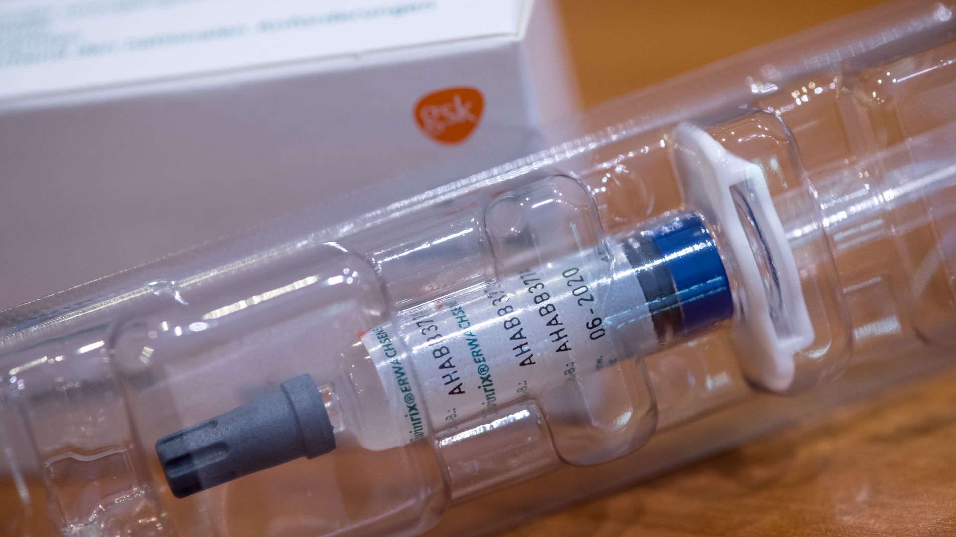 A vaccine syringe with a GlaxoSmithKline box in the background.