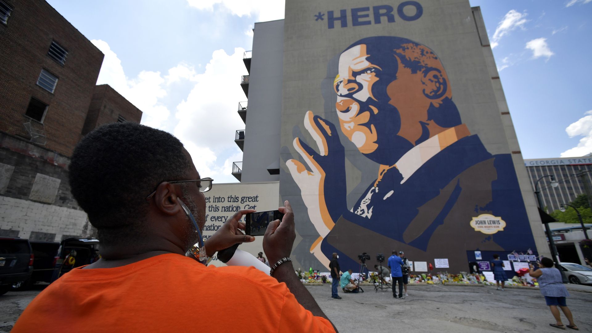 A person takes a photo of the 65-foot-tall mural of John Lewis in Sweet Auburn