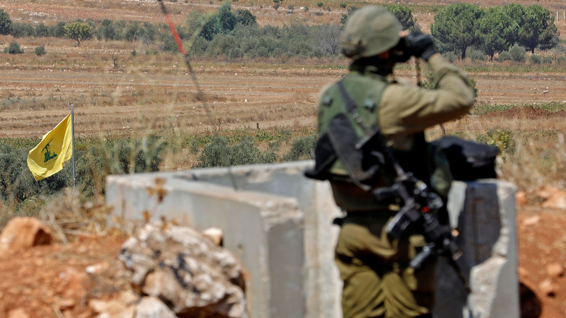 Israeli soldiers stand position in northern Israel along the border with Lebanon near a flag of the Lebanese Shiite movement Hezbollah, on September 12, 2022.