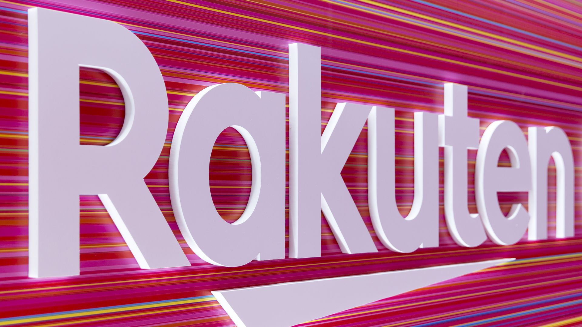 Rakuten's name is spelled out in white lettering against a pink-infused background.