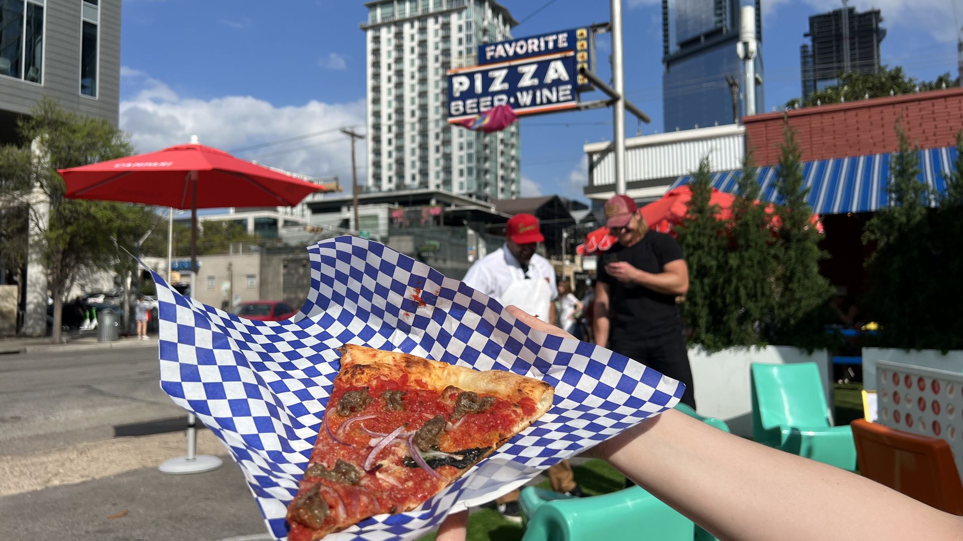 A photo of pizza in the foreground and a sign in the background.