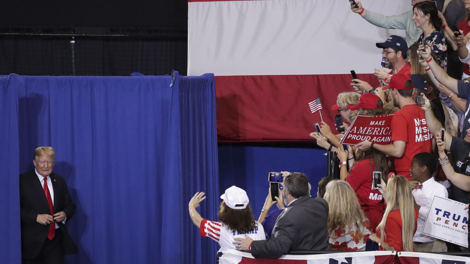 Trump on the left and supporters in the stands on the right