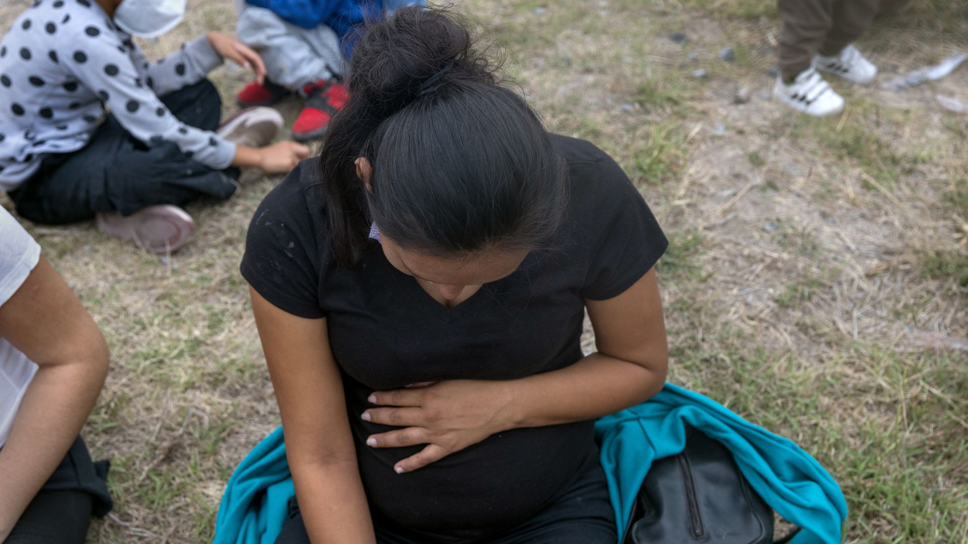 A Salavadoran woman, five months pregant, waits to board a U.S. Customs and Border Protection bus.