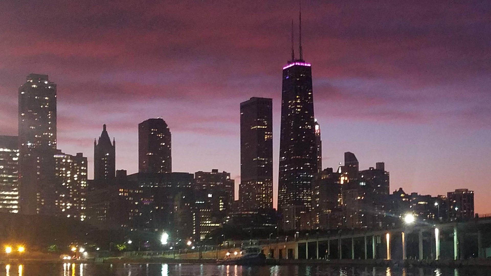 Photo of tall buildings in front of a body of water. 