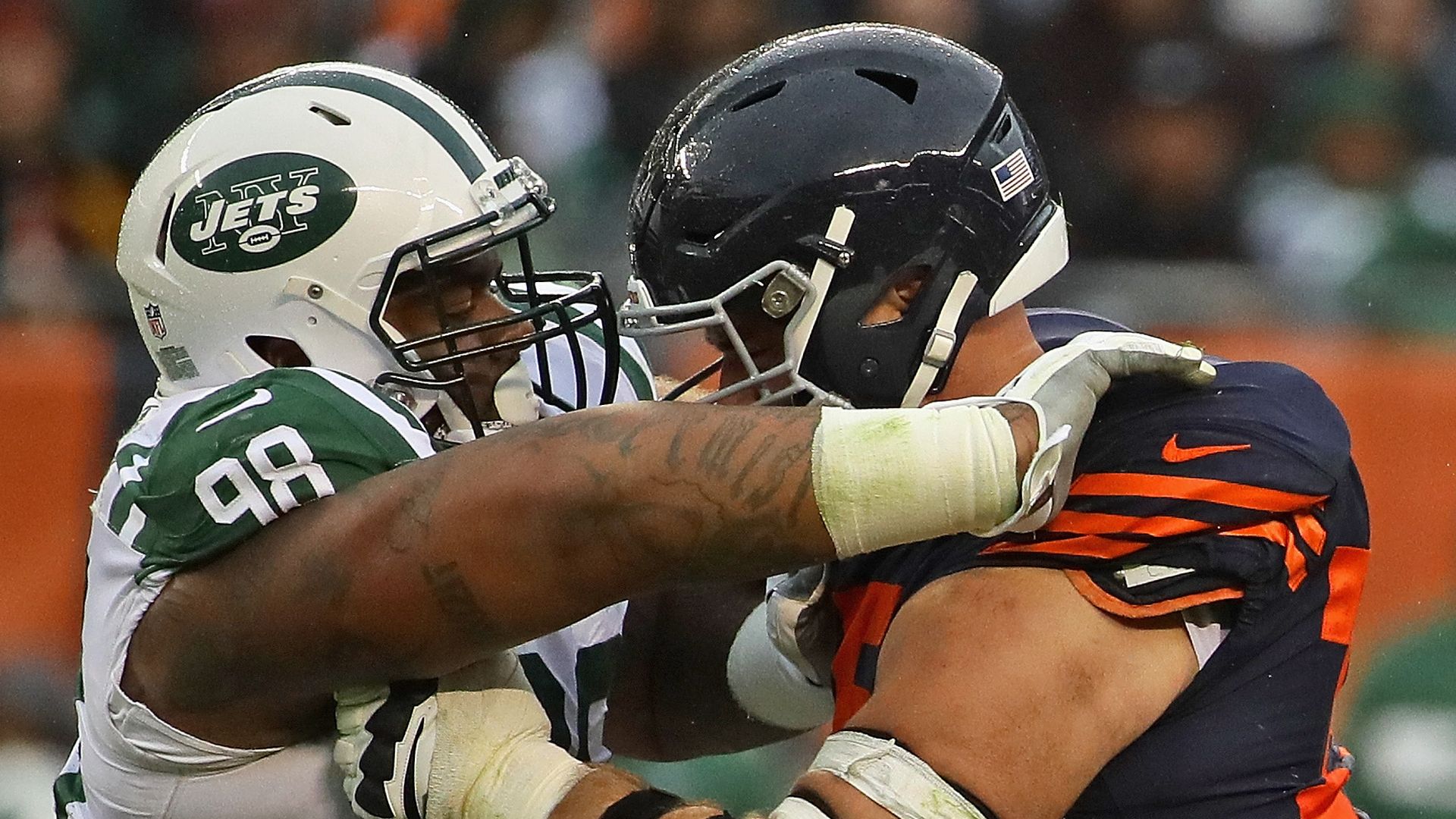 Photo of two football players tackling each other.