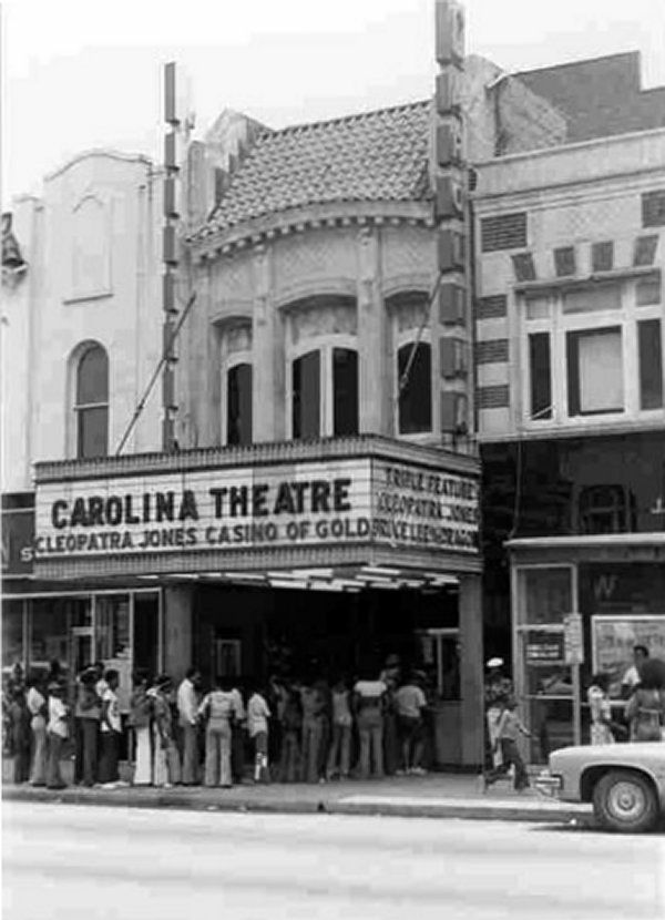 People line up outside the theatre in an old black and white photo