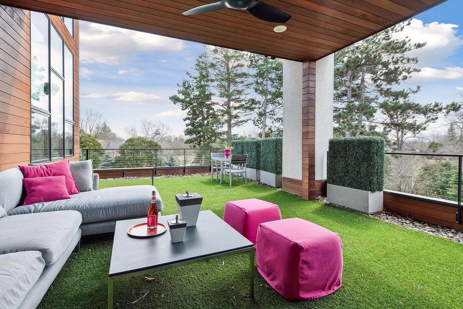 A patio with astroturf and pink furniture.