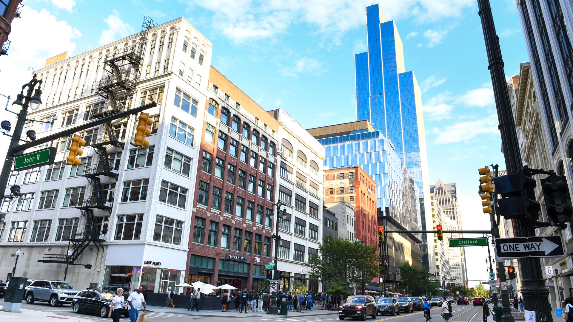 A view of a line of storefronts and the tall Hudson's development