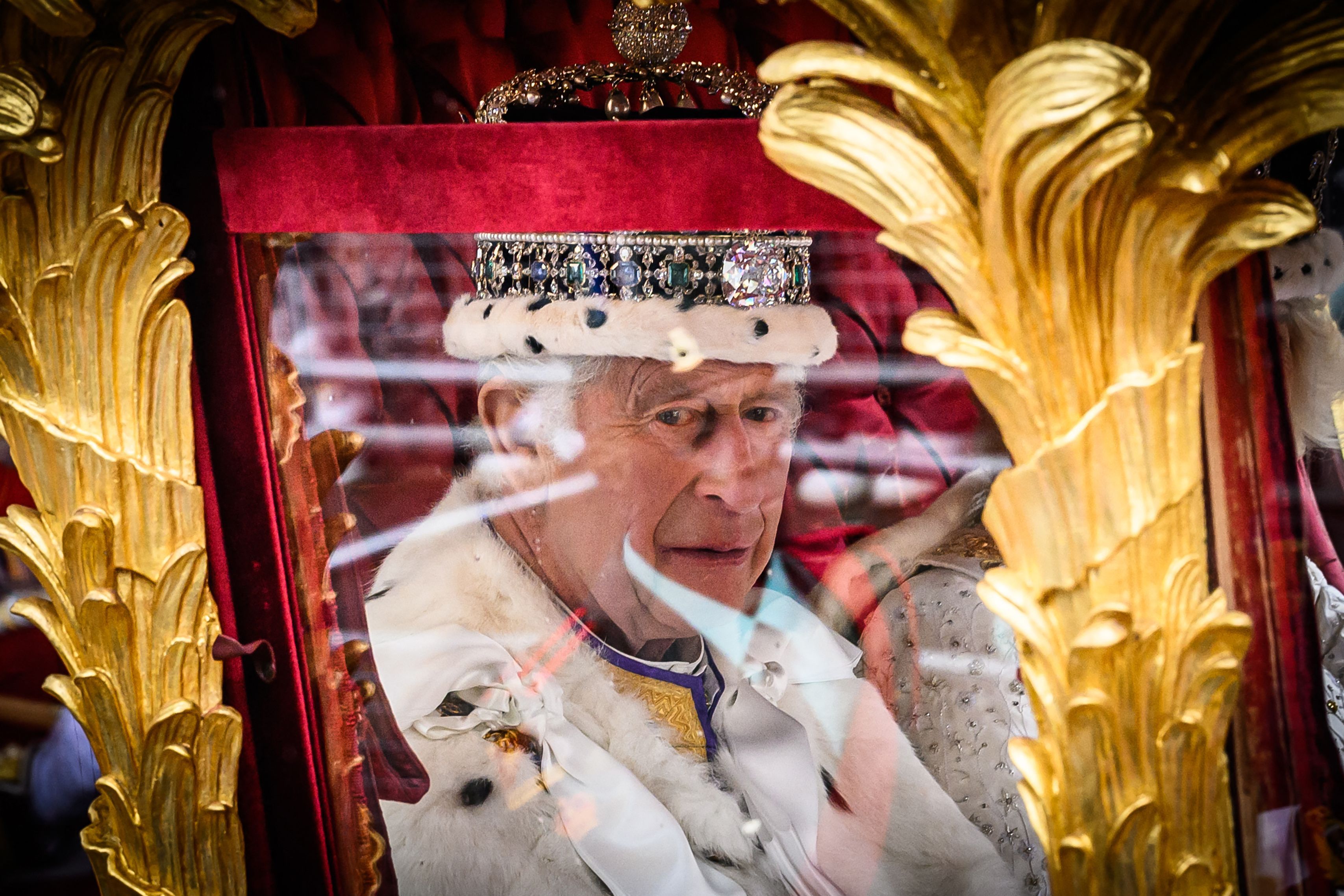 A close up image of King Charles III in a carriage on the way to his coronation.
