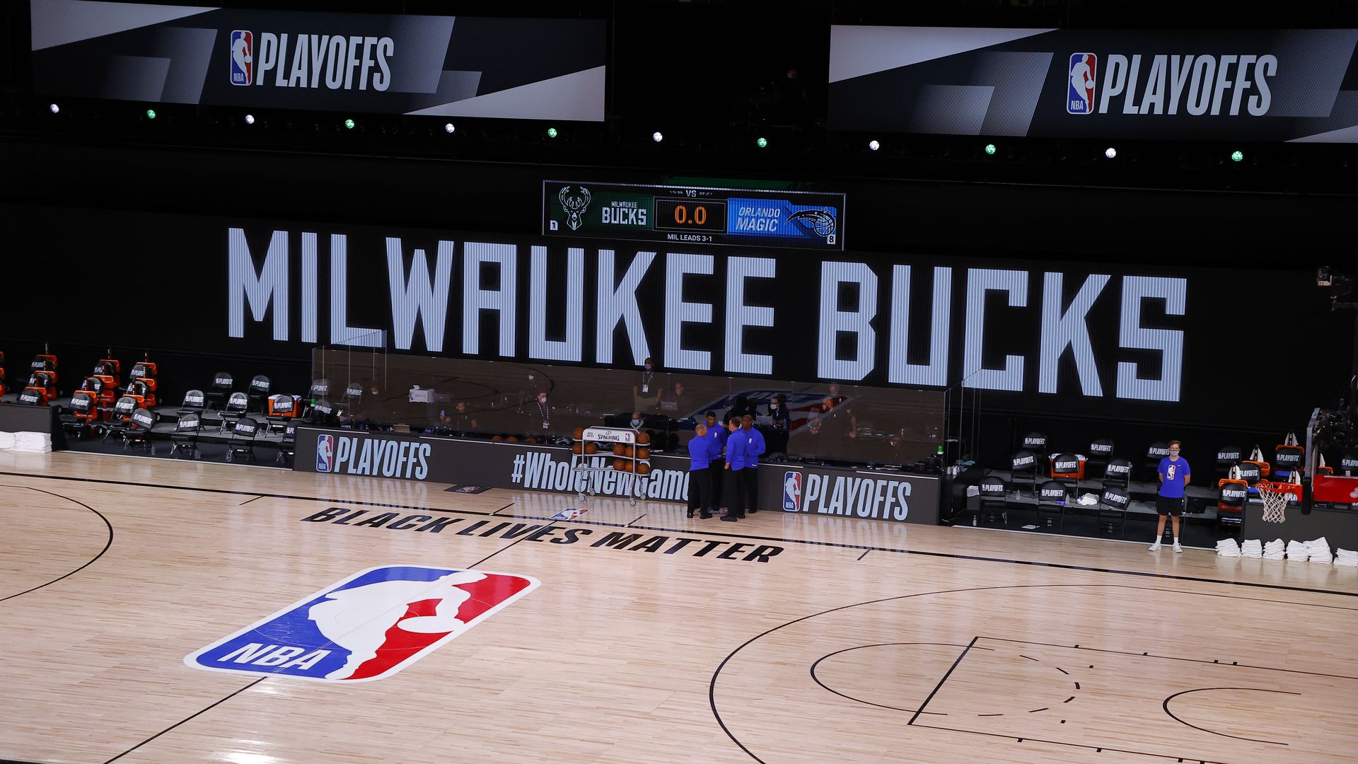 Referees huddle on an empty court at game time of a game between the Milwaukee Bucks and Orlando Magic for Game during the 2020 NBA Playoffs in Lake Buena Vista, Florida.