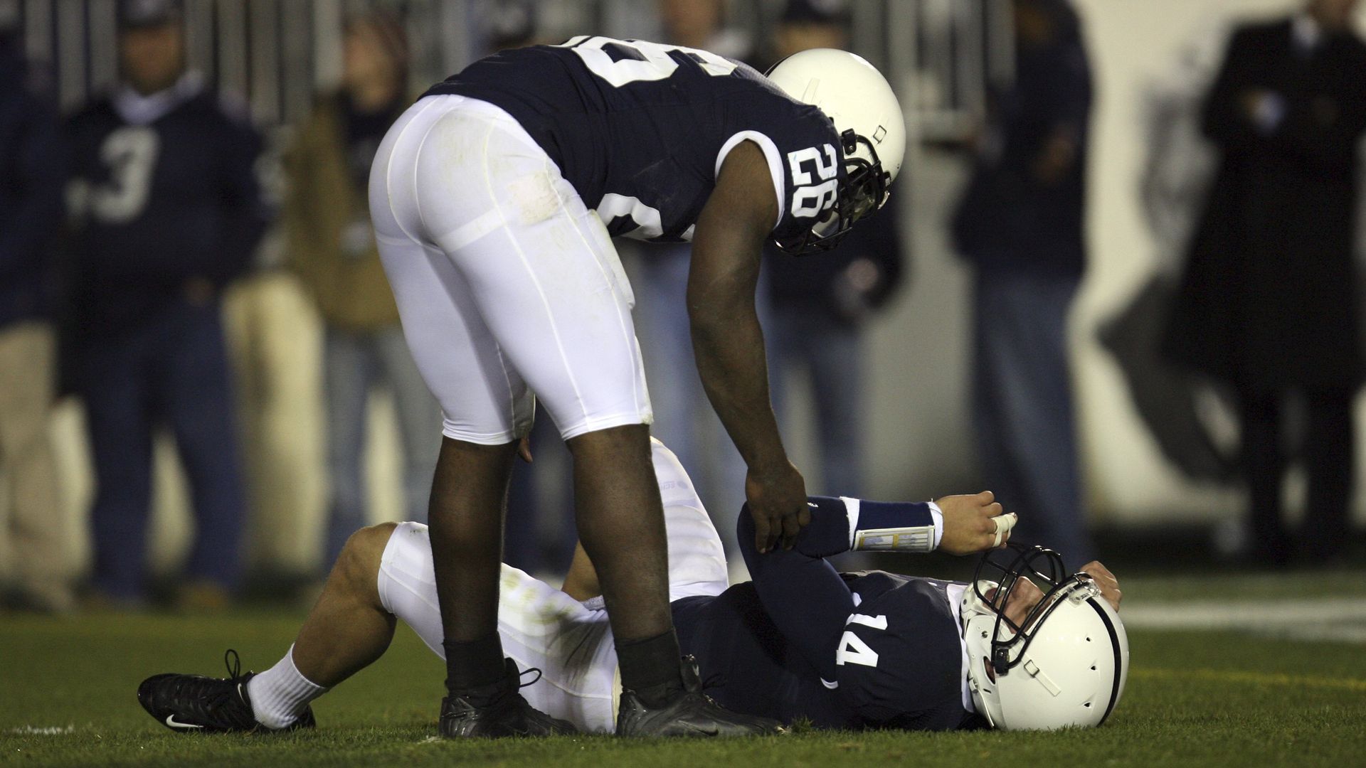 penn state football player lies on the ground with a concussion