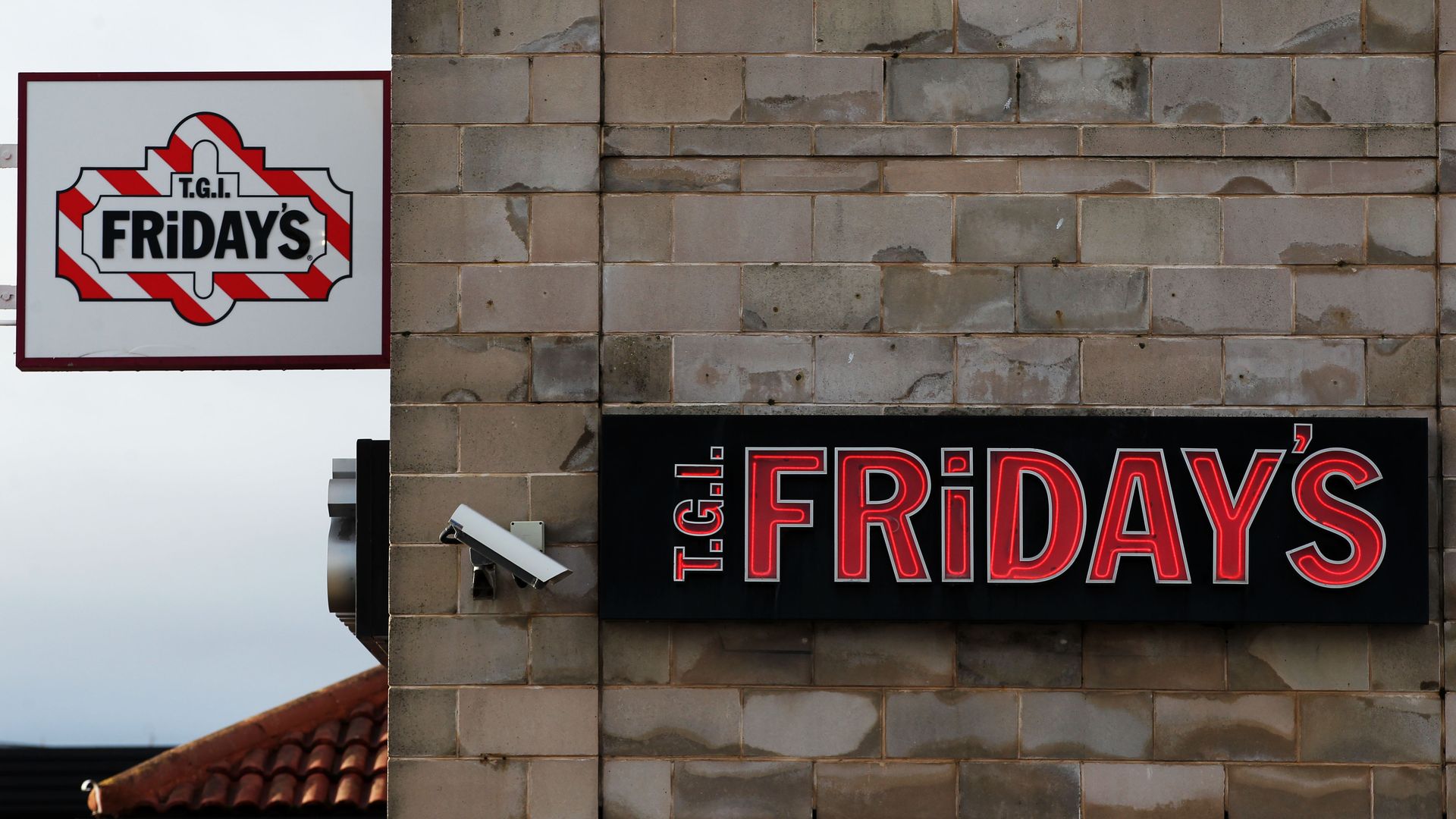 A surveillance camera next to a T.G.I. Friday’s sign
