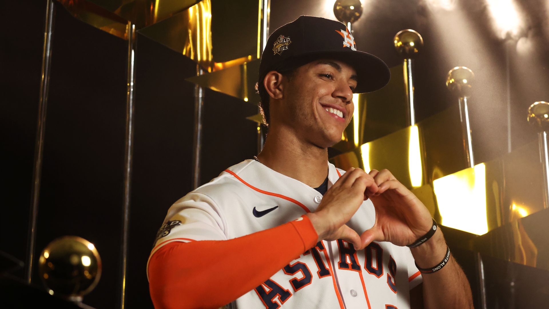 Astros infielder Jeremy Peña, in uniform, makes a heart shape with his hands 