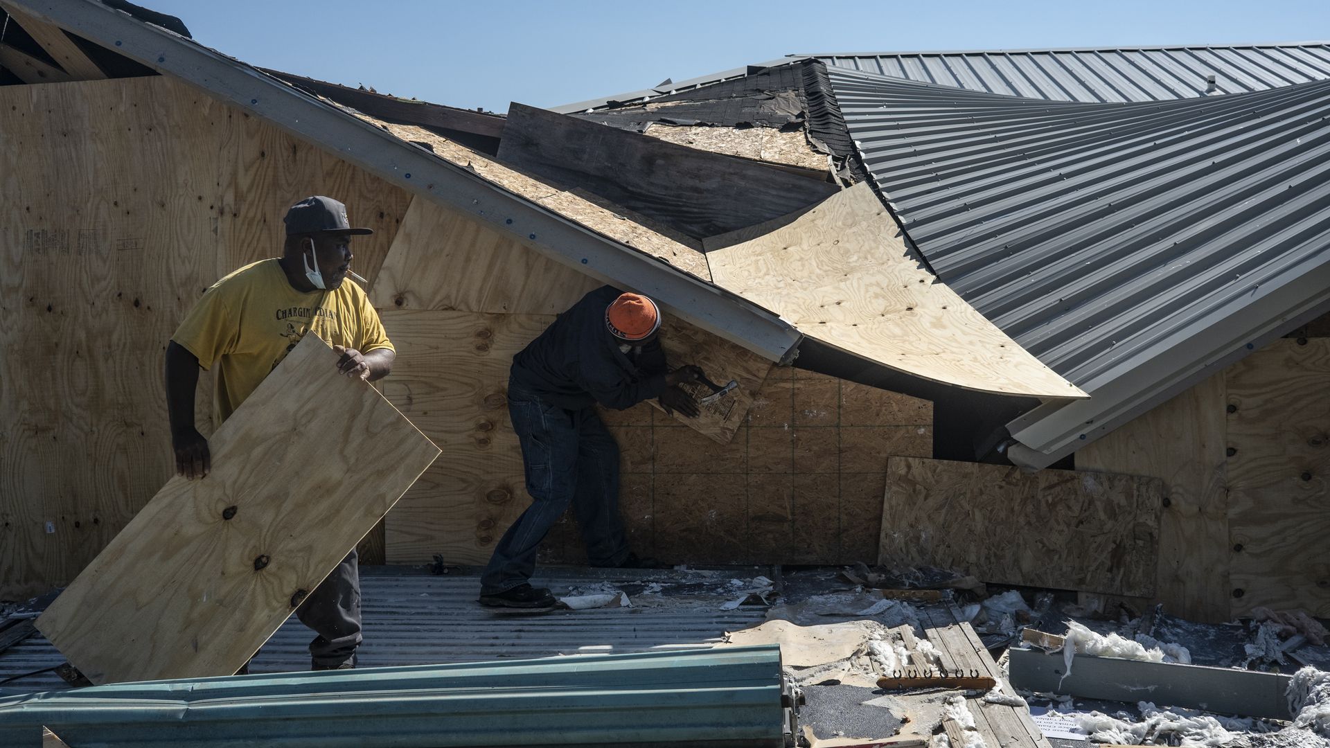 People work to seal the openings of a damaged bar on October 10, 2020 in Lake Charles, Louisiana.