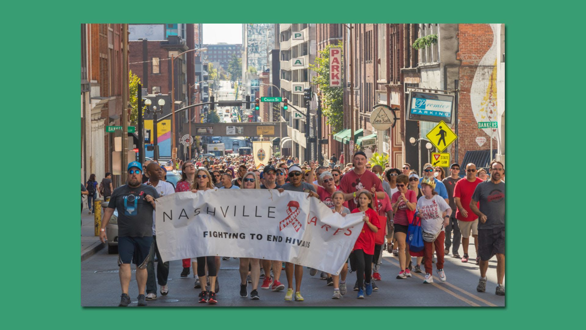 A group of people walking a previous Nashville AIDS Walk while holding a banner.