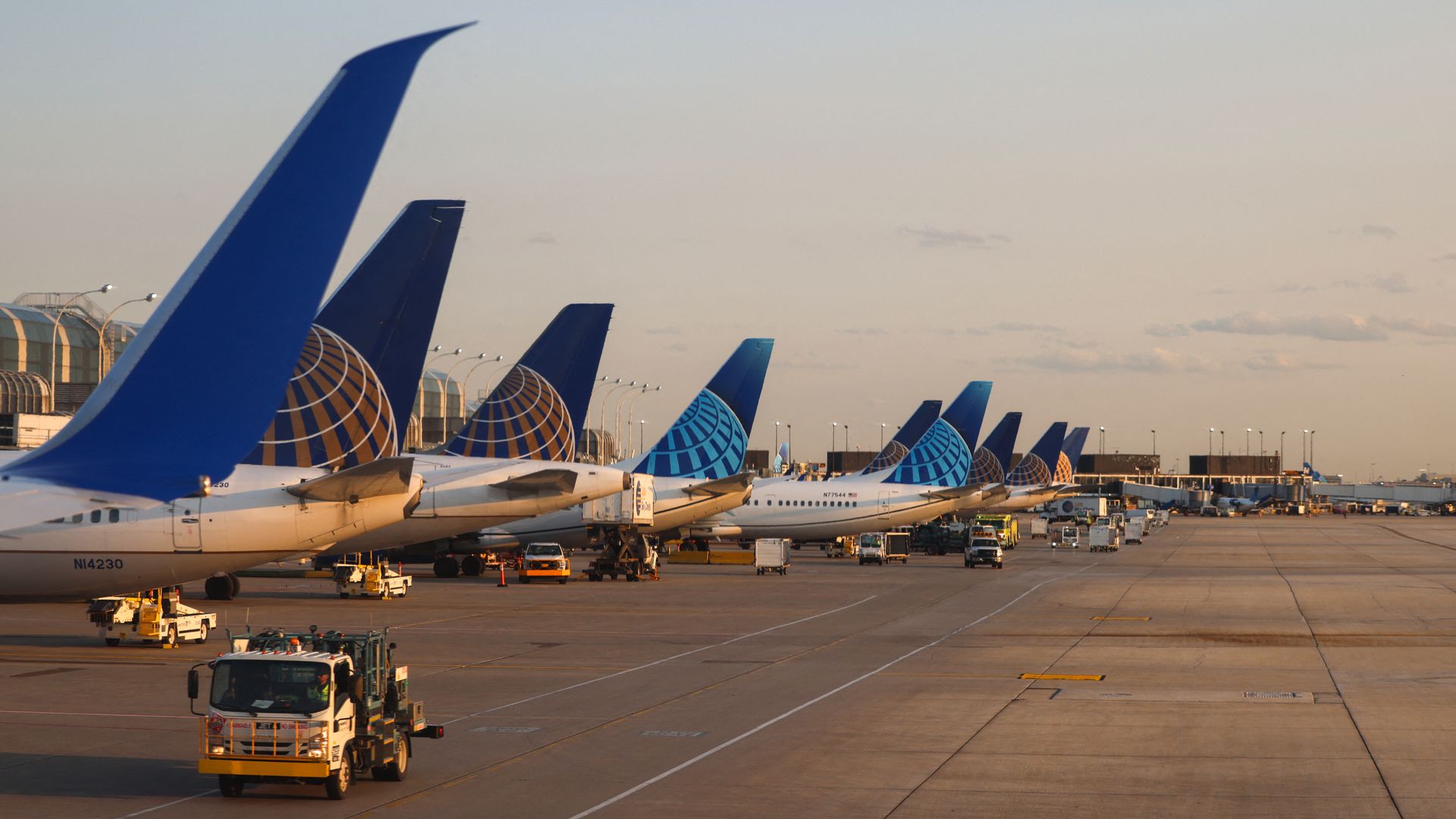 Photo of planes lined up along a runway at an airport. 