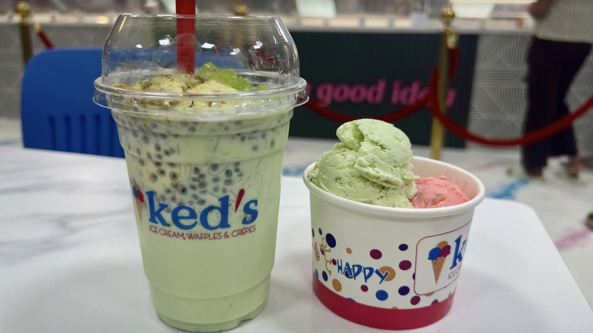 A green milk drink next to ice cream in a cup