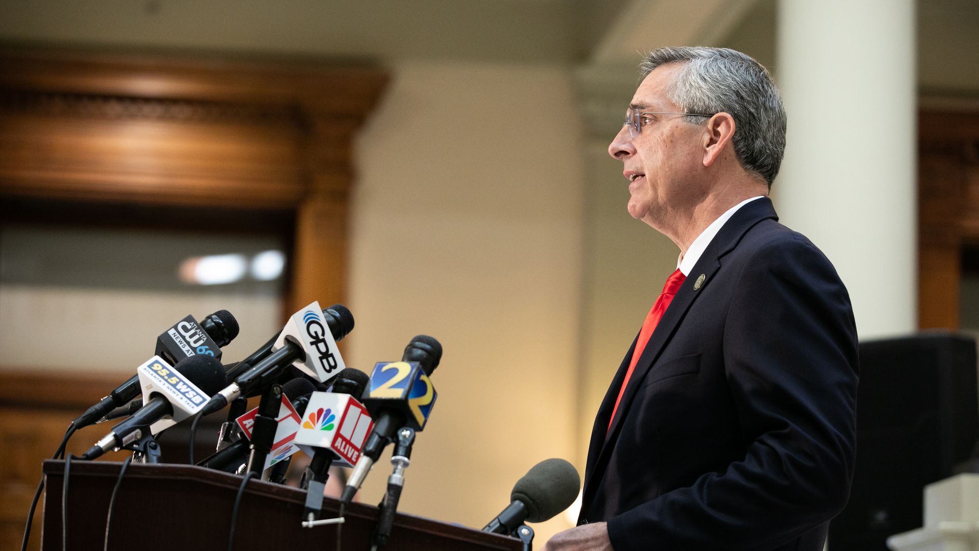 Brad Raffensperger at a podium with many microphones