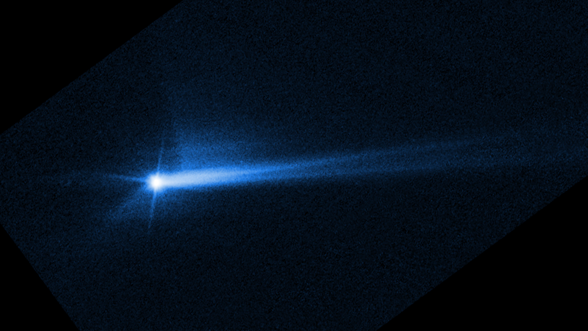A blue streak that shows debris blasted off of an asteroid