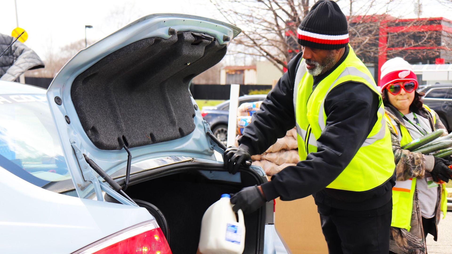A man loads milk into a trunk.