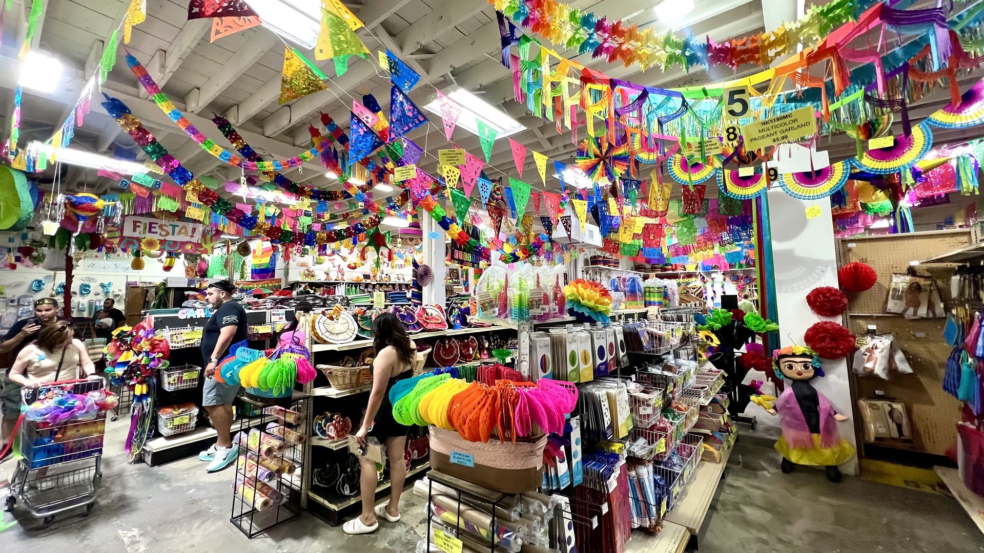 A very colorful and filled party store with Fiesta gear hanging from the ceiling. 