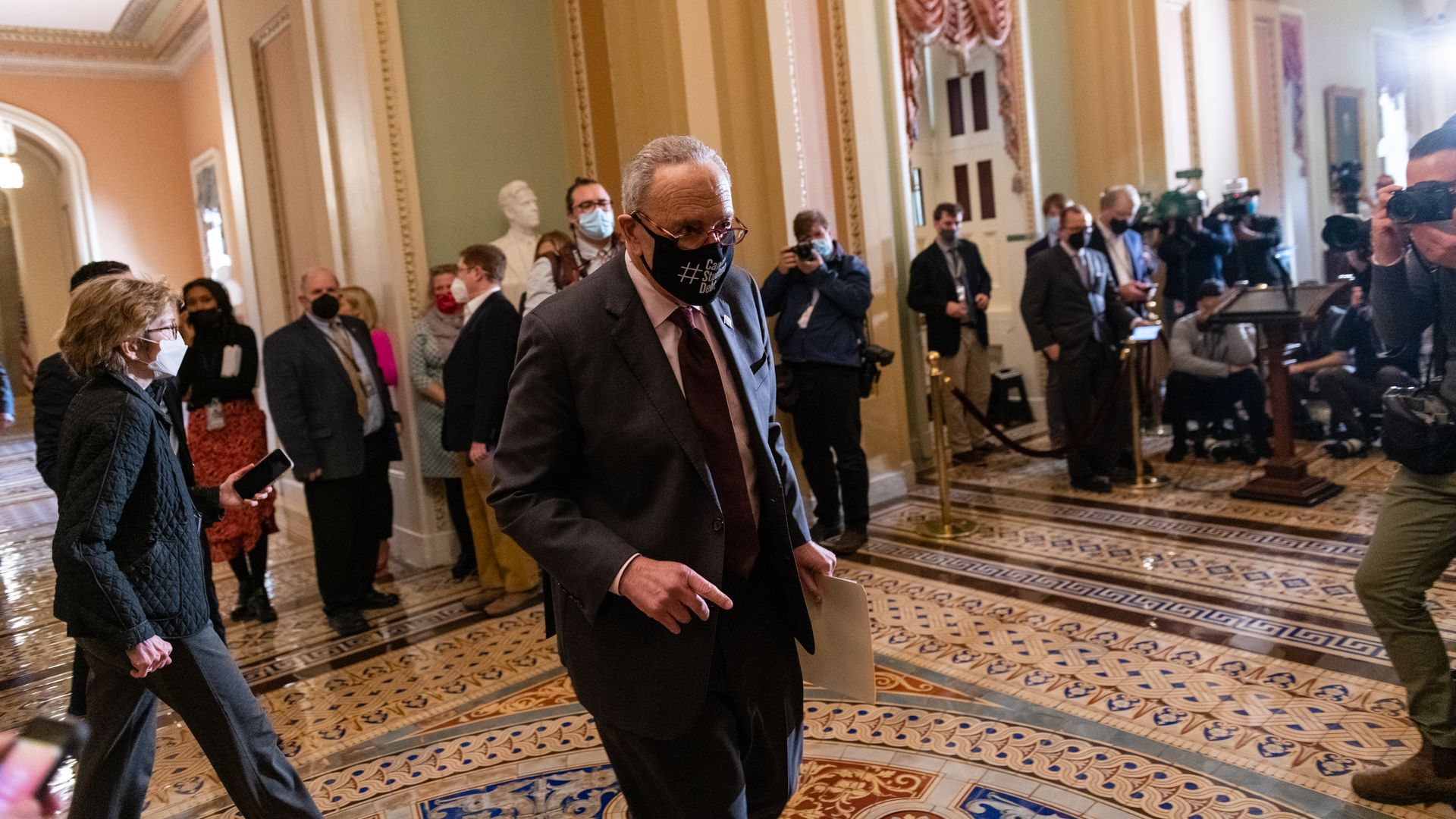 Senate Majority Leader Chuck Schumer is seen passing reporters on Tuesday.