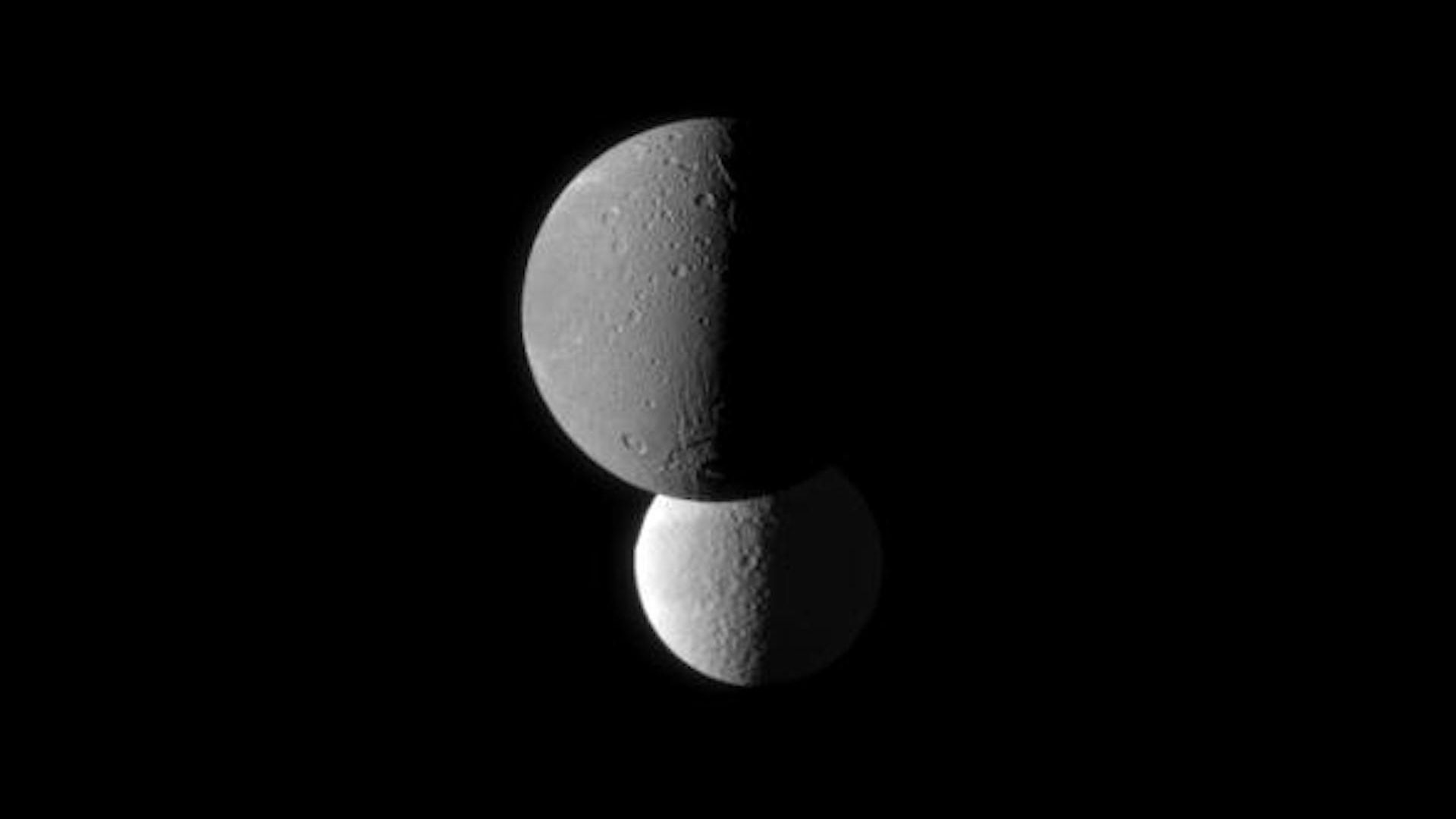 Two moons of Saturn in the blackness of space