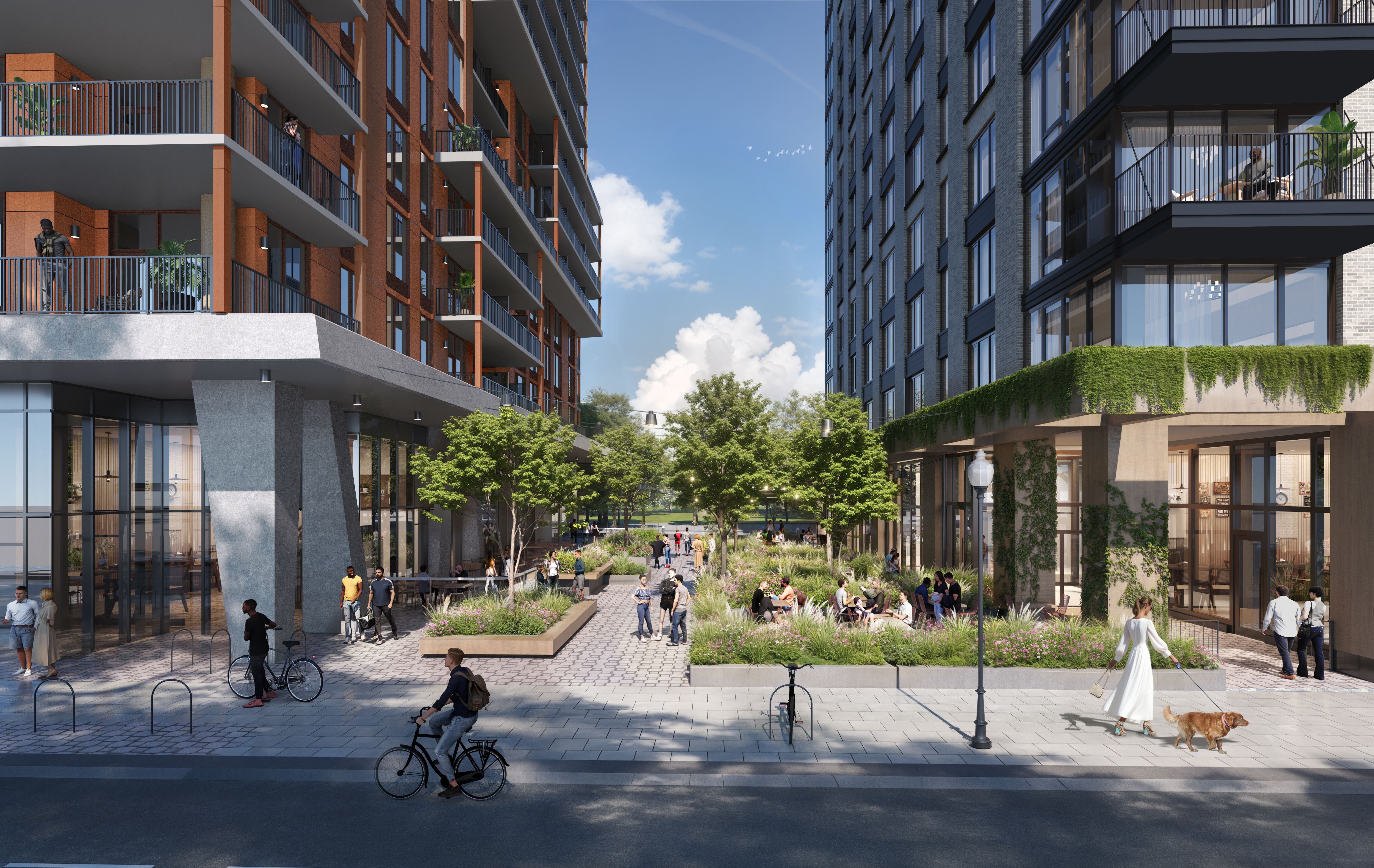 Urban scene with people walking, biking, and sitting in a courtyard between two modern apartment buildings with balconies, greenery, and a clear blue sky.