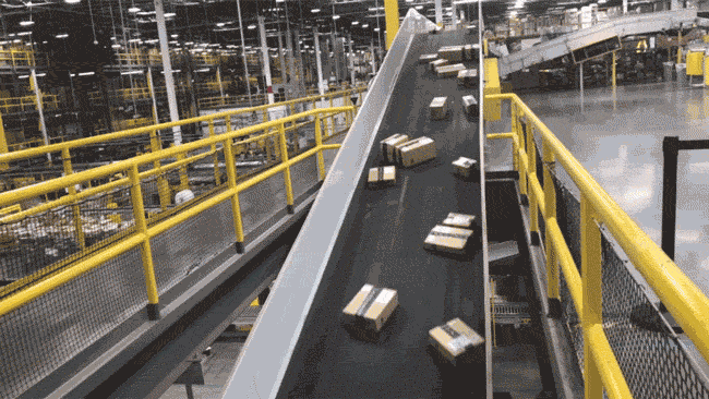 A gif of Amazon packages on a conveyer belt in a warehouse