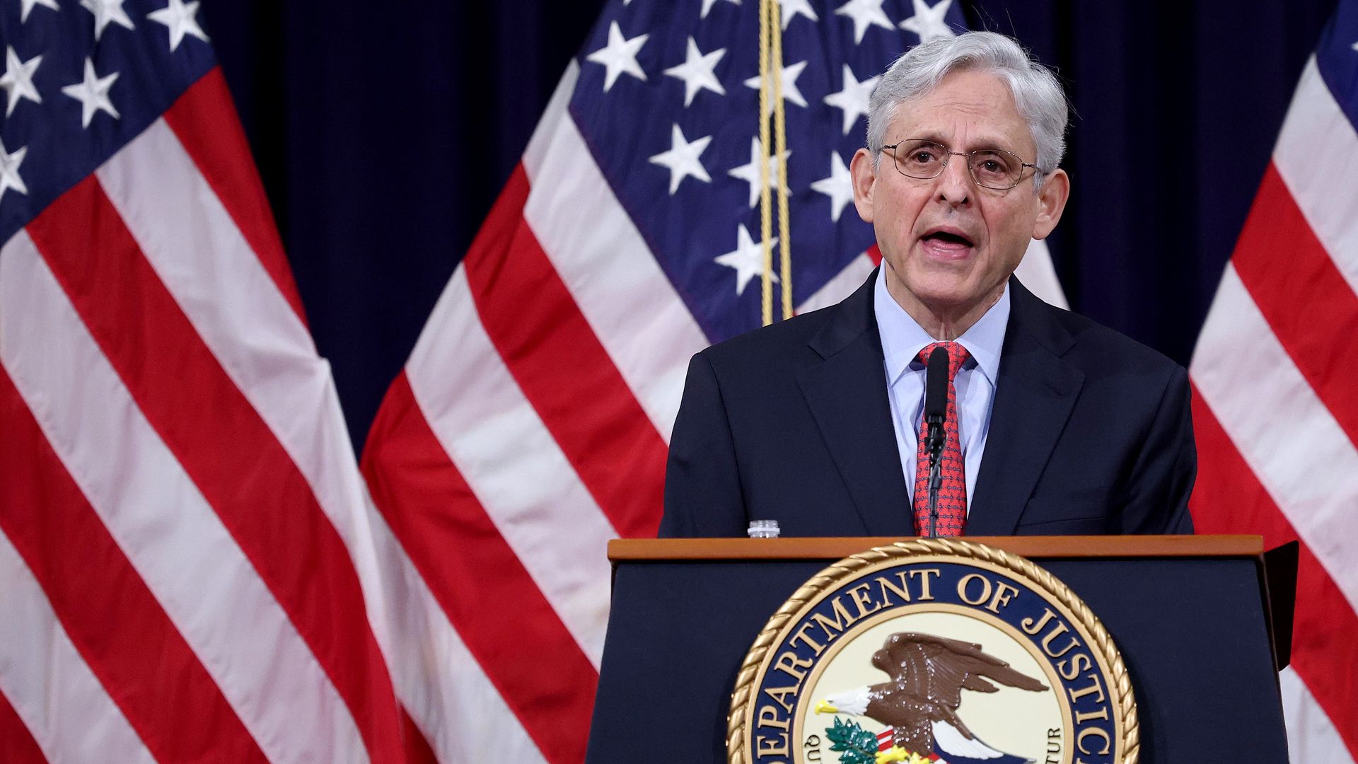 Photo of Merrick Garland speaking from a podium with the DOJ seal on it