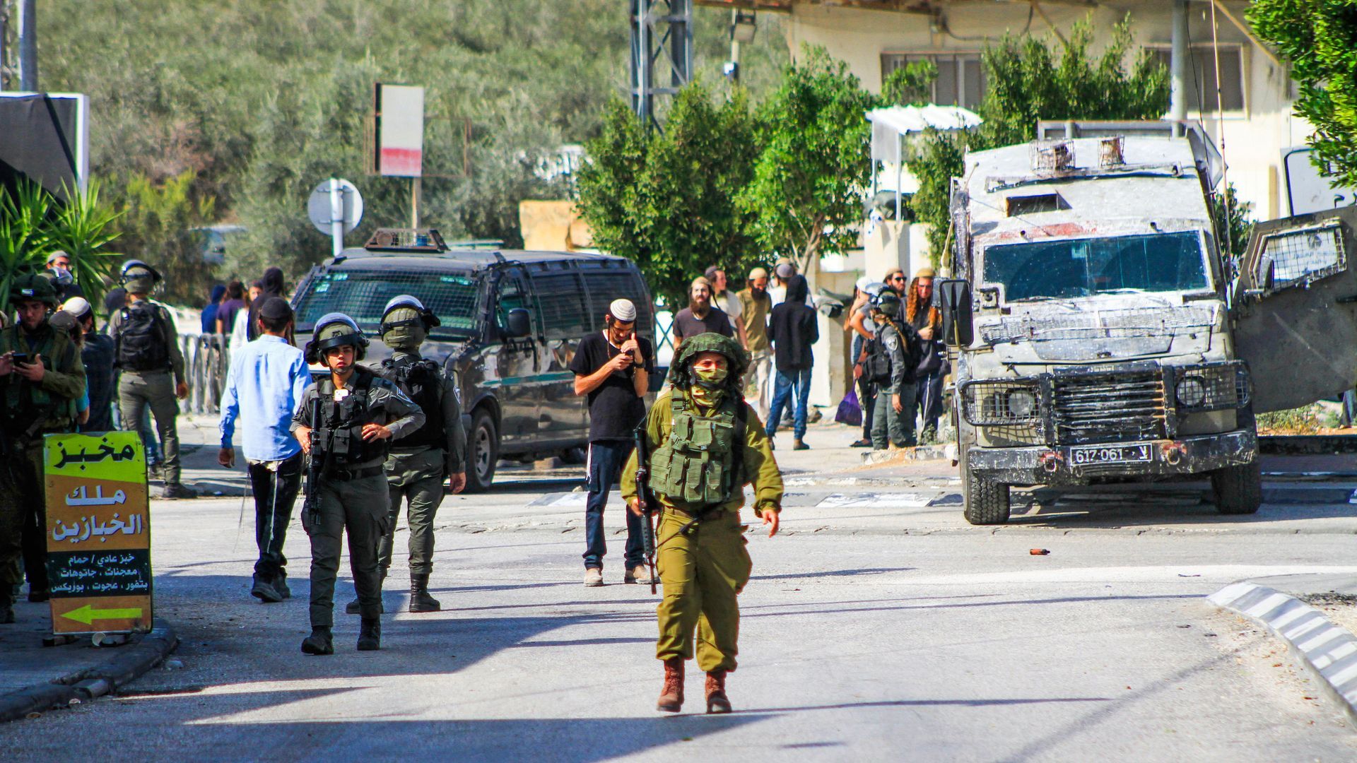 Israeli soldiers guard Jewish settlers after some launch an attack on the Palestinian town of Deir Sharaf following a shooting attack that killed an Israeli man in the area. Photo: Nasser Ishtayeh/SOPA Images/LightRocket via Getty Images