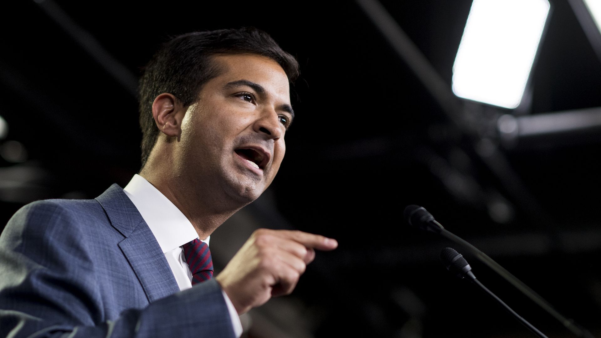 Carlos Curbelo speaks enthusiastically and points a finger at the audience
