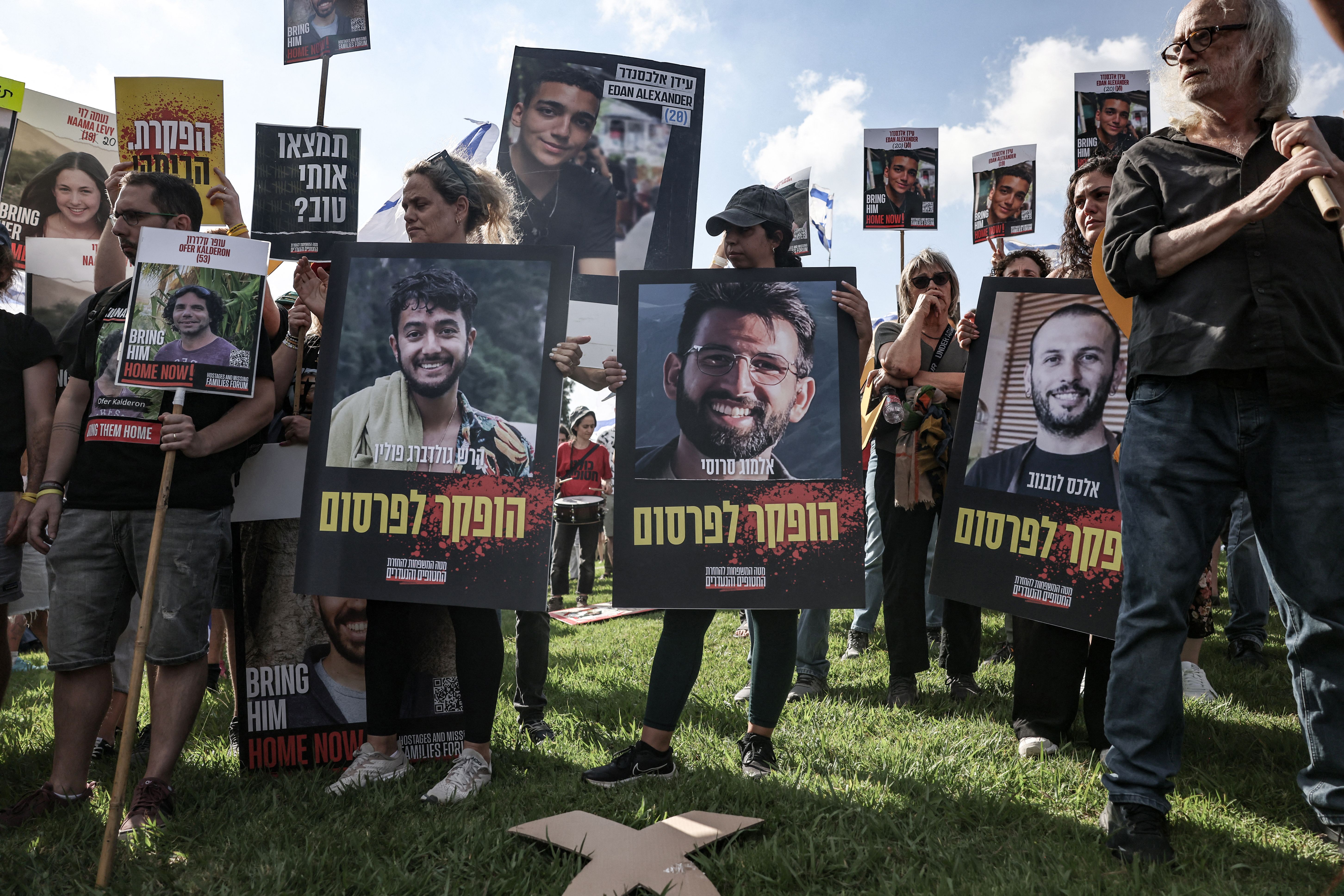 Relatives and supporters of Israeli hostages taken captive in the Gaza Strip since the October 7 attacks by Palestinian Hamas militants, carry pictures of Hersh Goldberg-Polin (L), Almog Sarusi (C) and Alexander Lubanov as they protest outside the prime minister's office in Jerusalem on September 1.