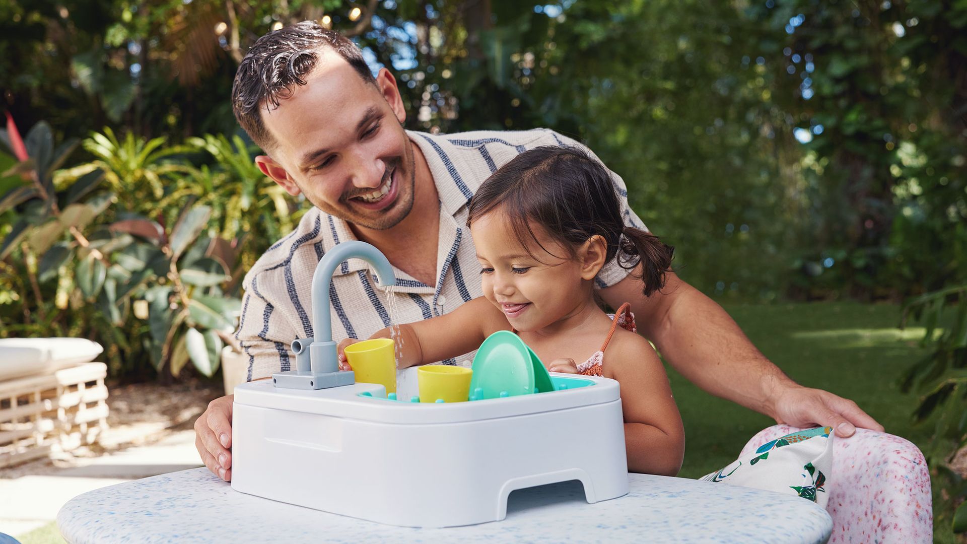 A father plays with his daughter, using toys for early childhood development.