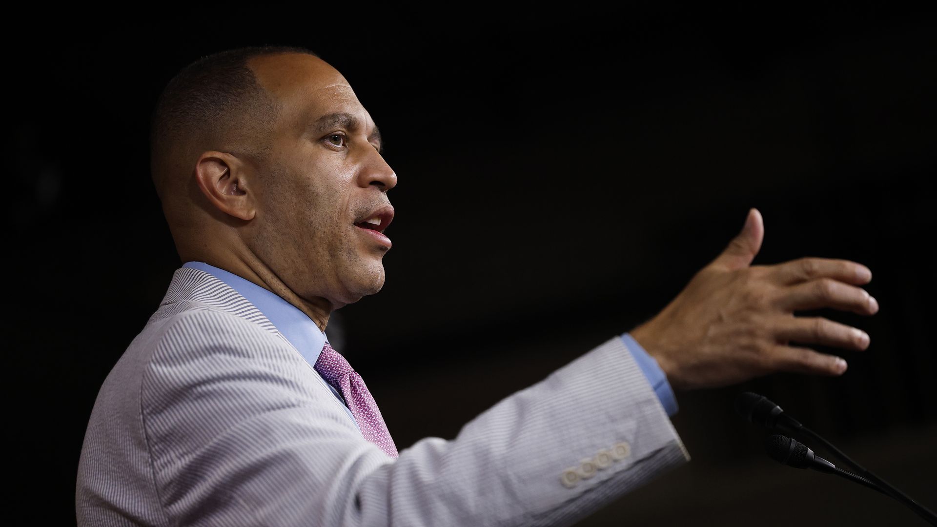 Hakeem Jeffries, wearing a light gray suit, gestures as he speaks during a press conference.