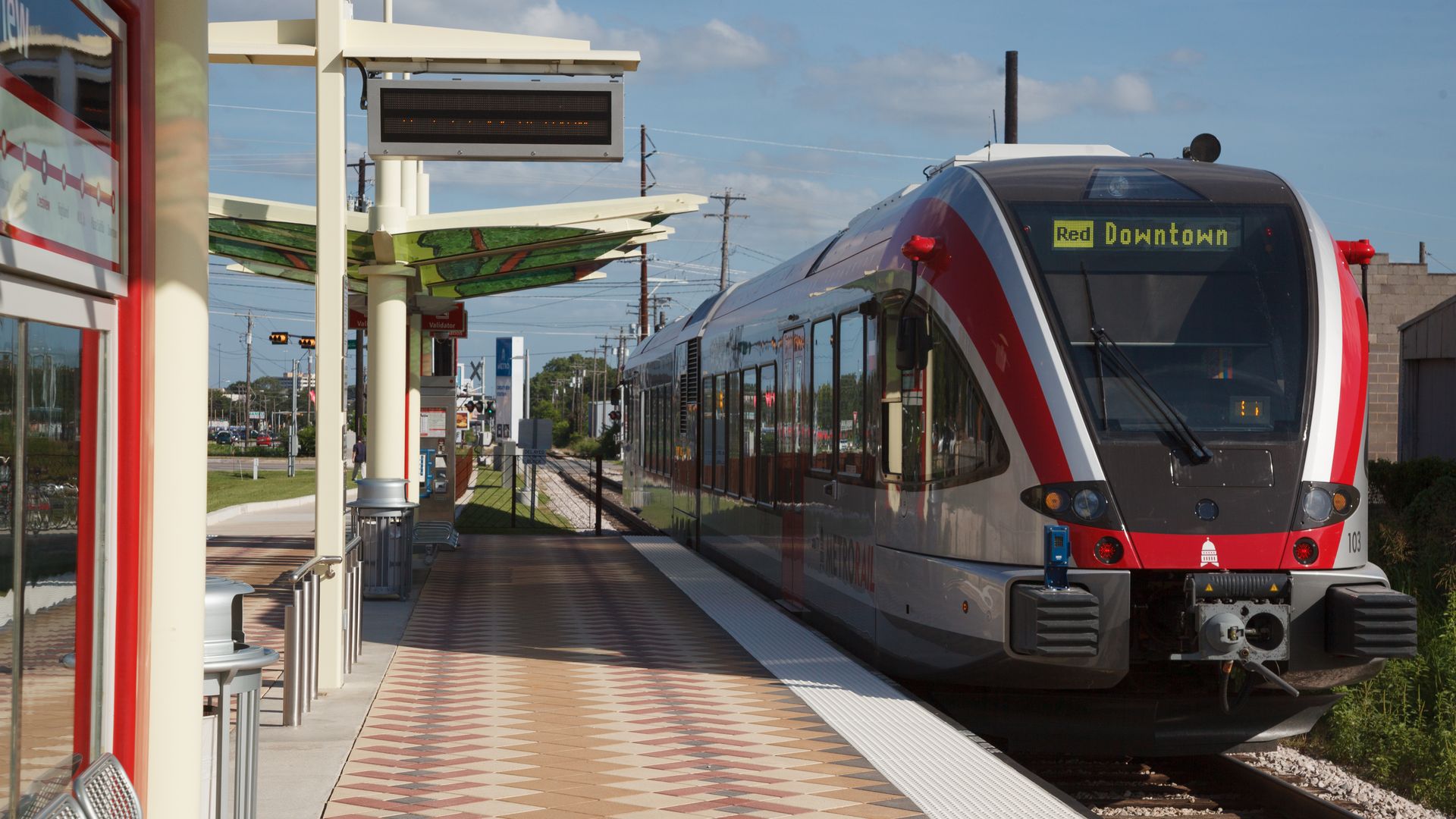 A red line light rail train stopped in Austin.