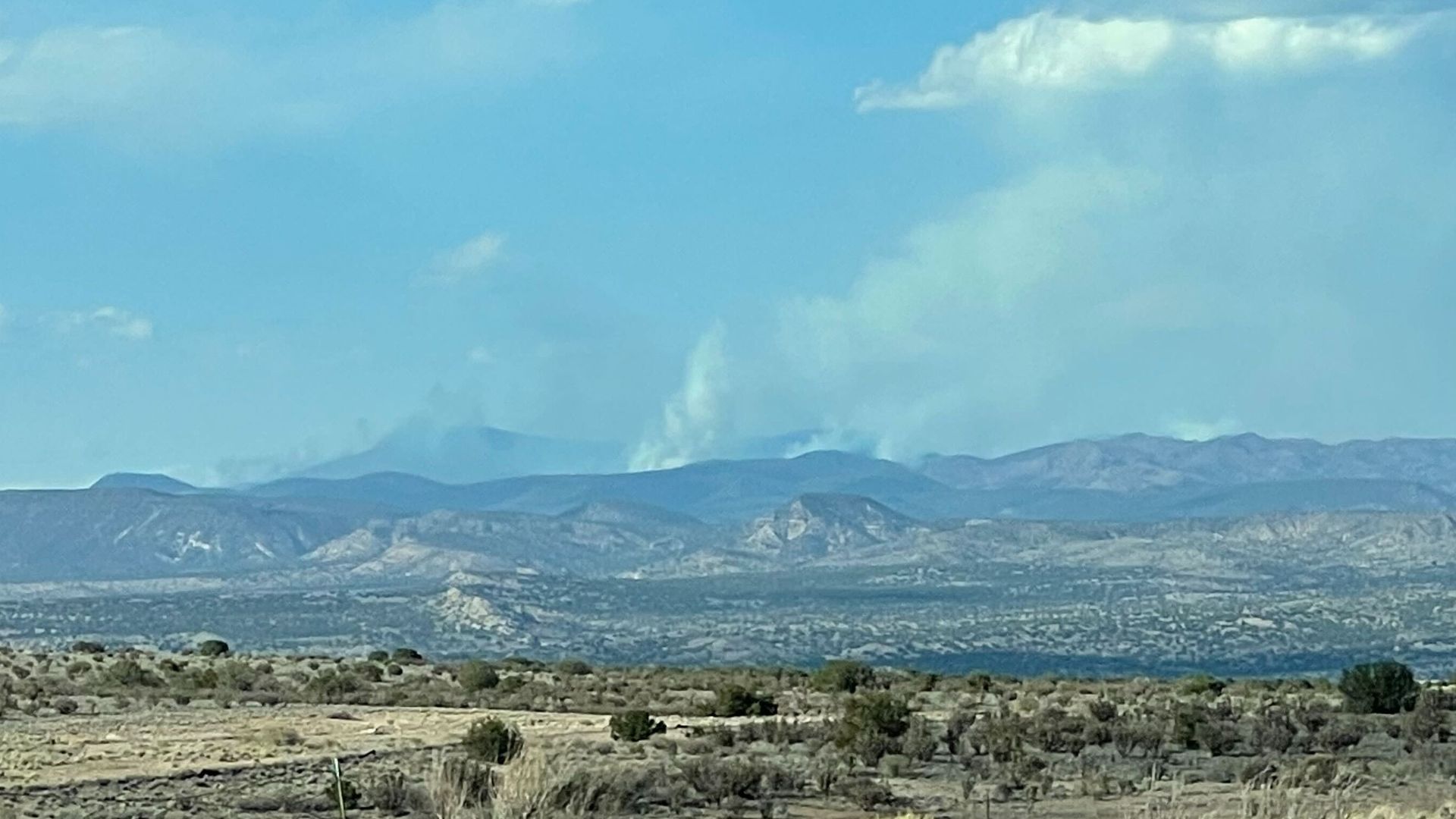 The scene from Rio Rancho, N.M., look toward a fire in Santa Fe National Forest in northern New Mexico.