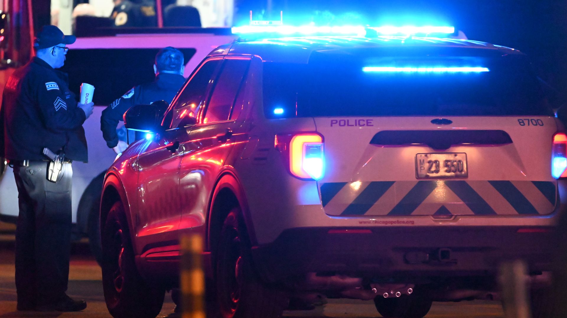 Photo of a police car with its lights on at night. 