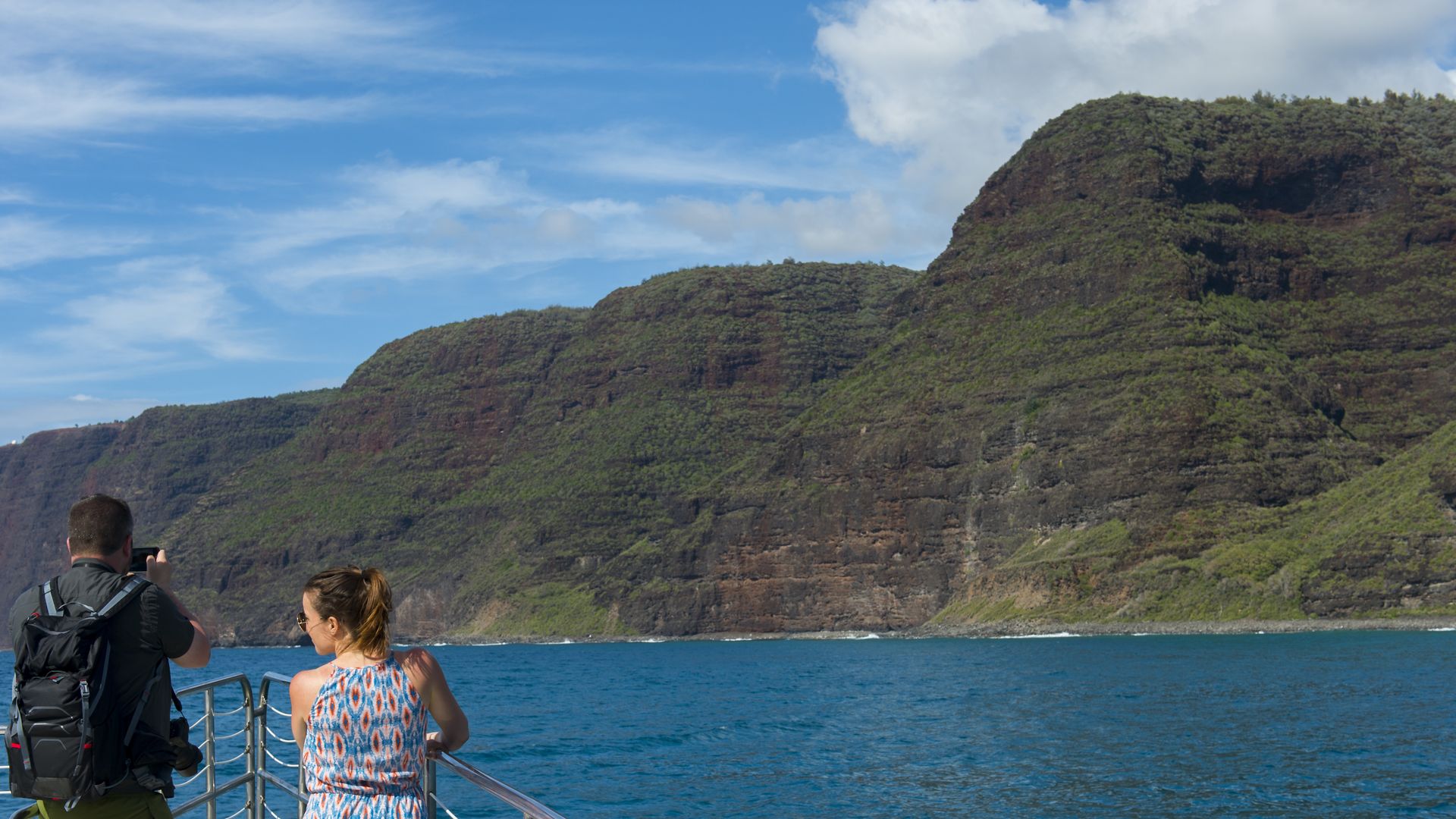 People on an excursion boat looking at the Na Pali Coast on the western side of the Hawaiian Island of Kauai, Hawaii