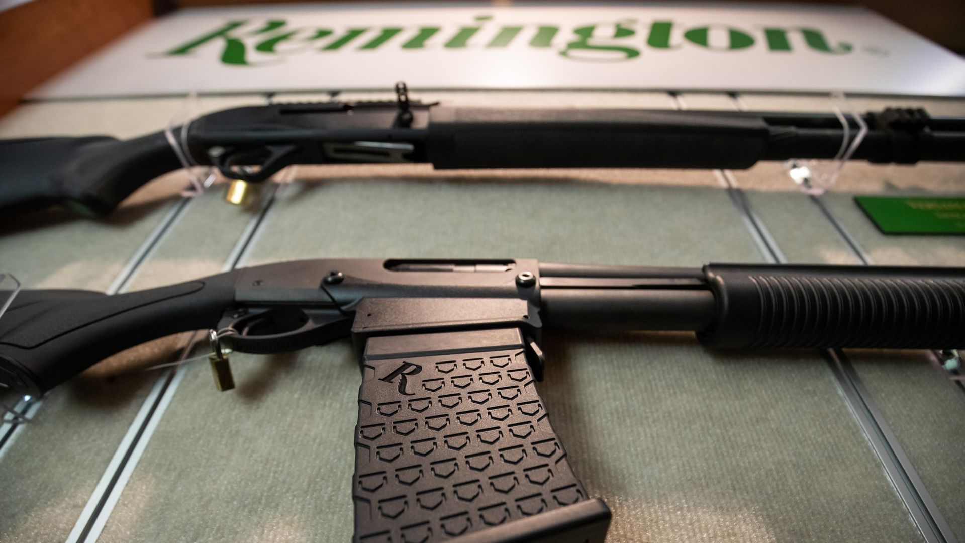 Two Remington rifles lay underneath the Remington logo. 