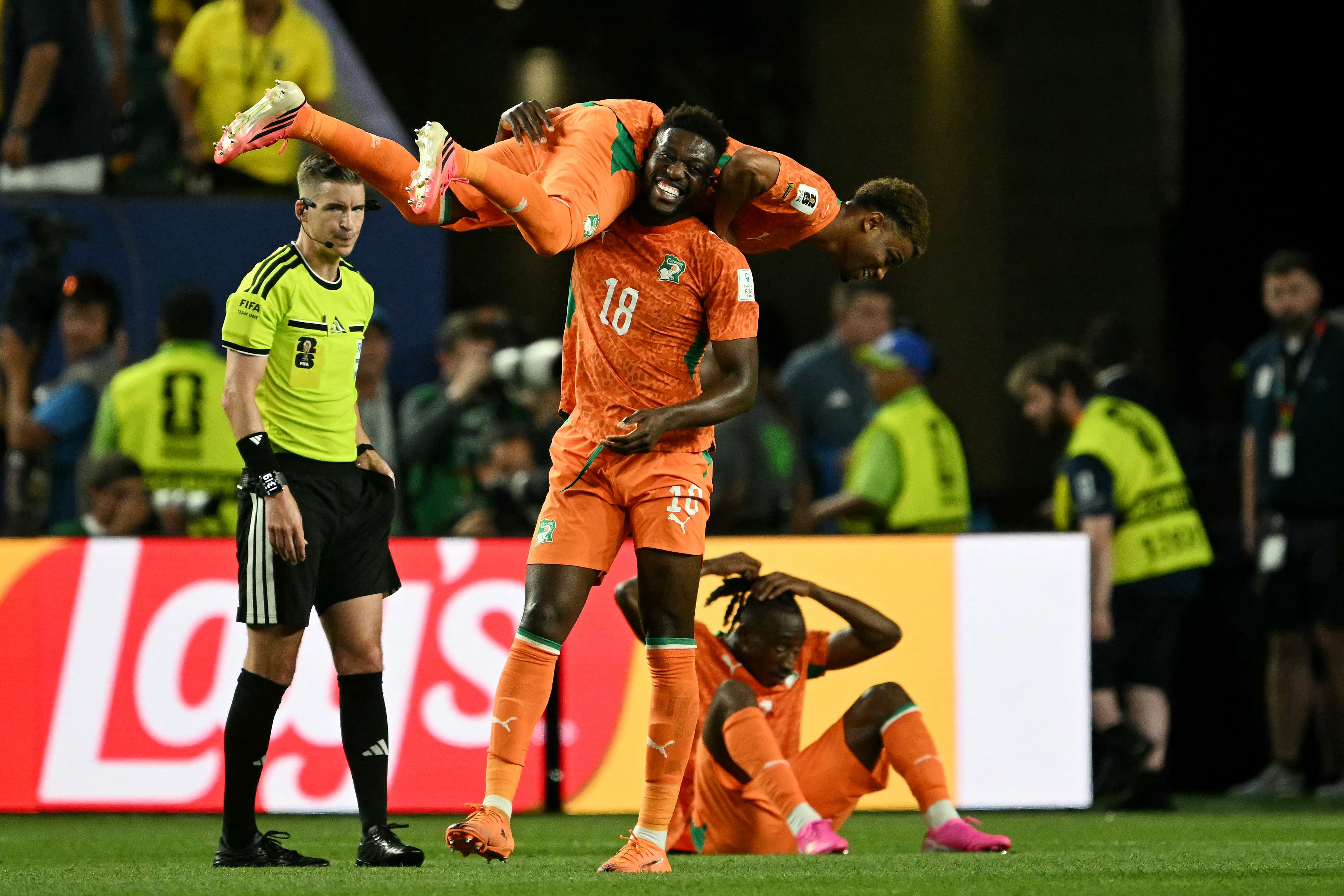 Ivory Coast's midfielder #18 Ibrahim Sangare carries forward #15 Amad Diallo as they celebrate after winning the 2026 World Cup Group E football match.