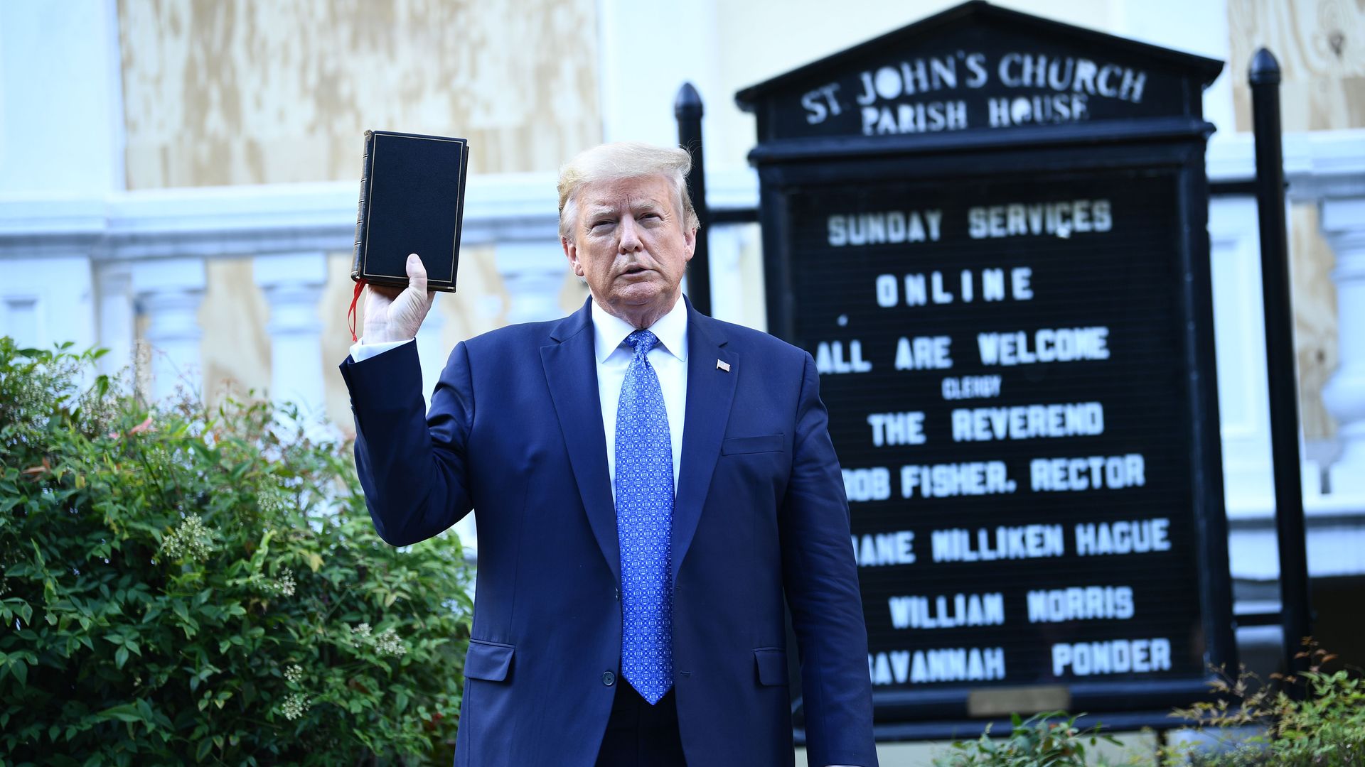 Photo of Donald Trump holding up a black Bible next to a St. John's Church sign
